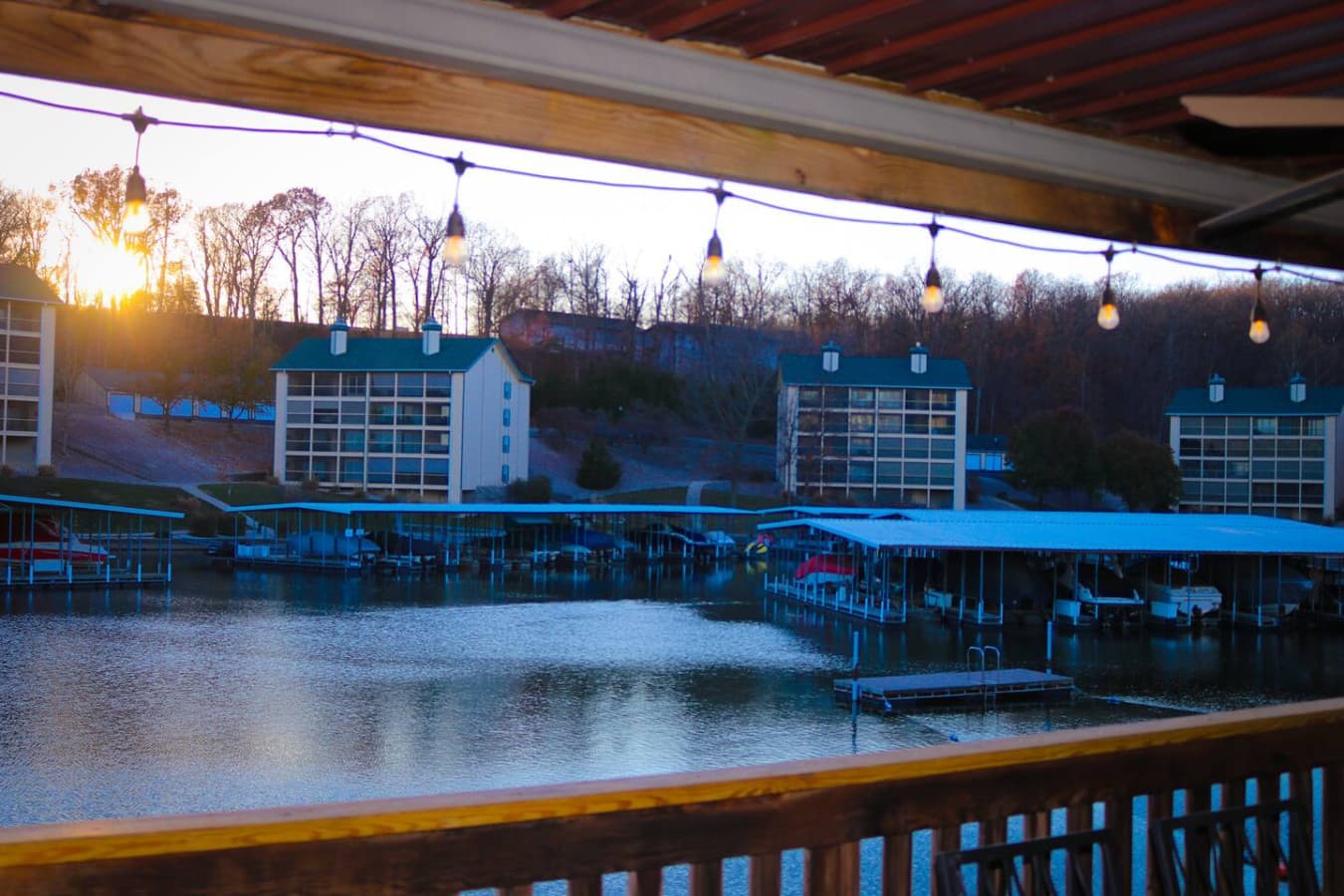 String lights set the perfect mood for evening drinks with a serene waterfront backdrop.