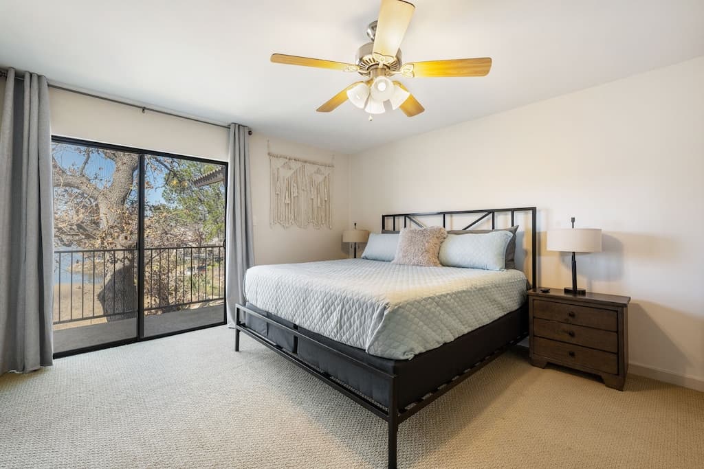 King Bedroom 2 - access to balcony, views of the lake, smart TV, & full bathroom