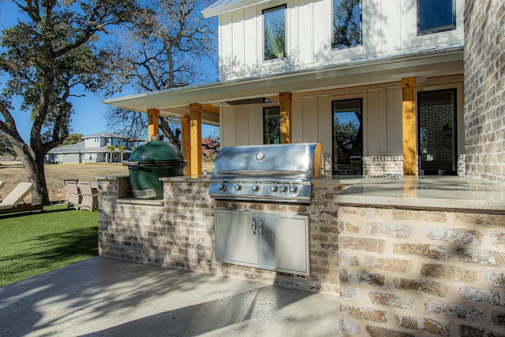 Green Egg with supplies and Gas grill. Dropdown outdoor TV