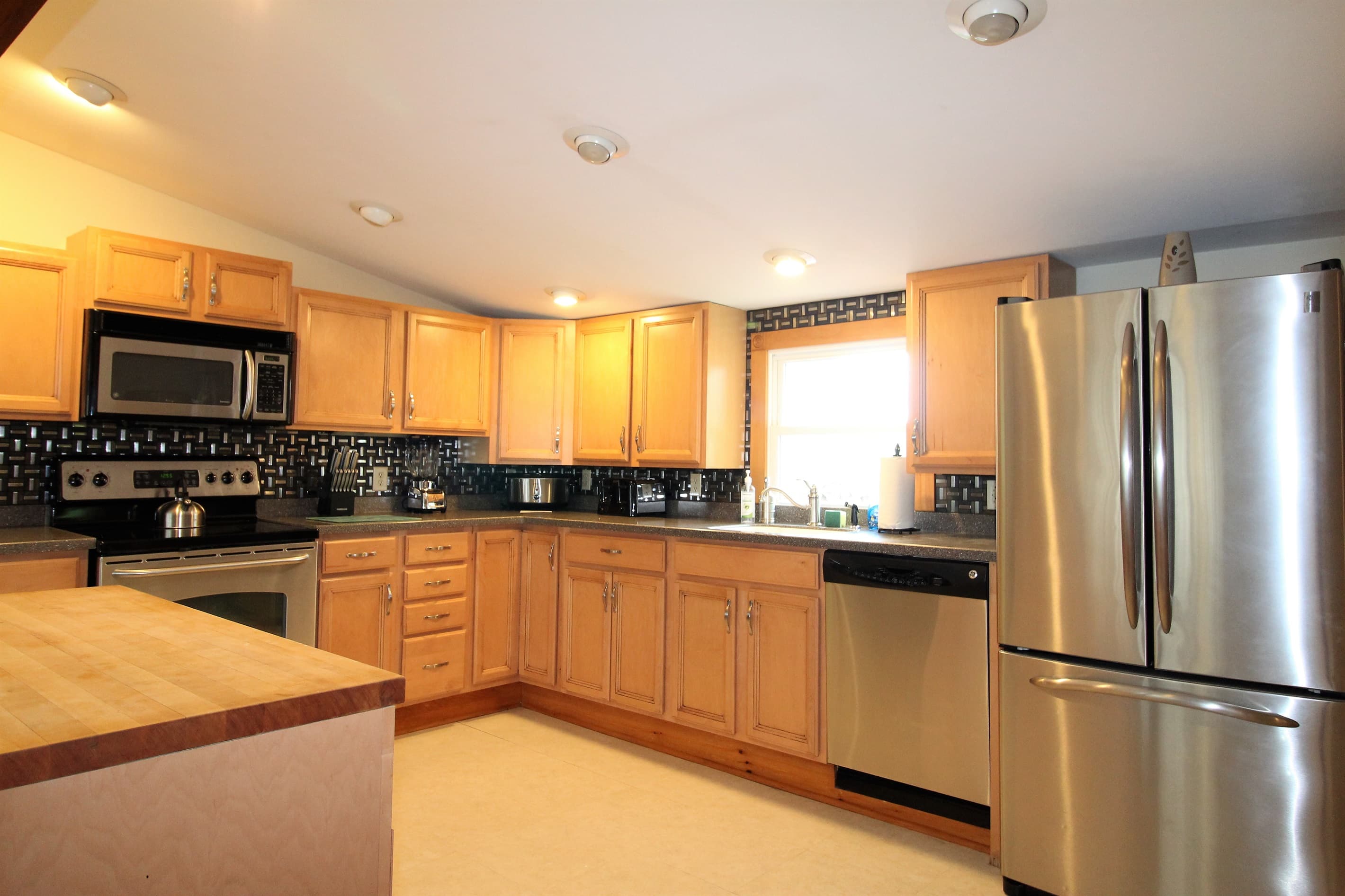 Stainless steel appliances with over the range microwave, dishwasher, and refrigerator with automatic ice maker