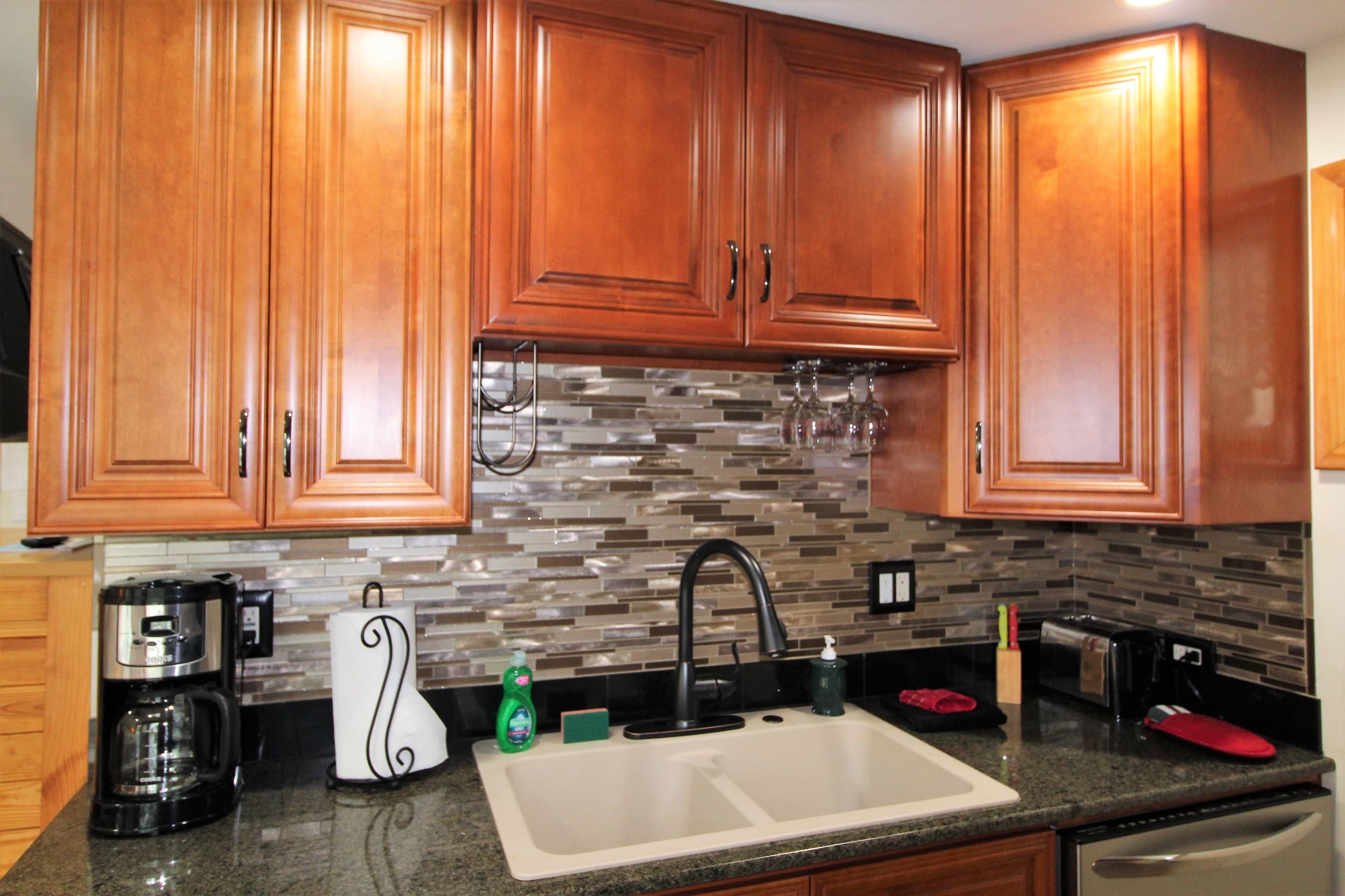 Wet bar in the upper level suite with newly tiled backsplash, dishwasher and microwave (not pictured)