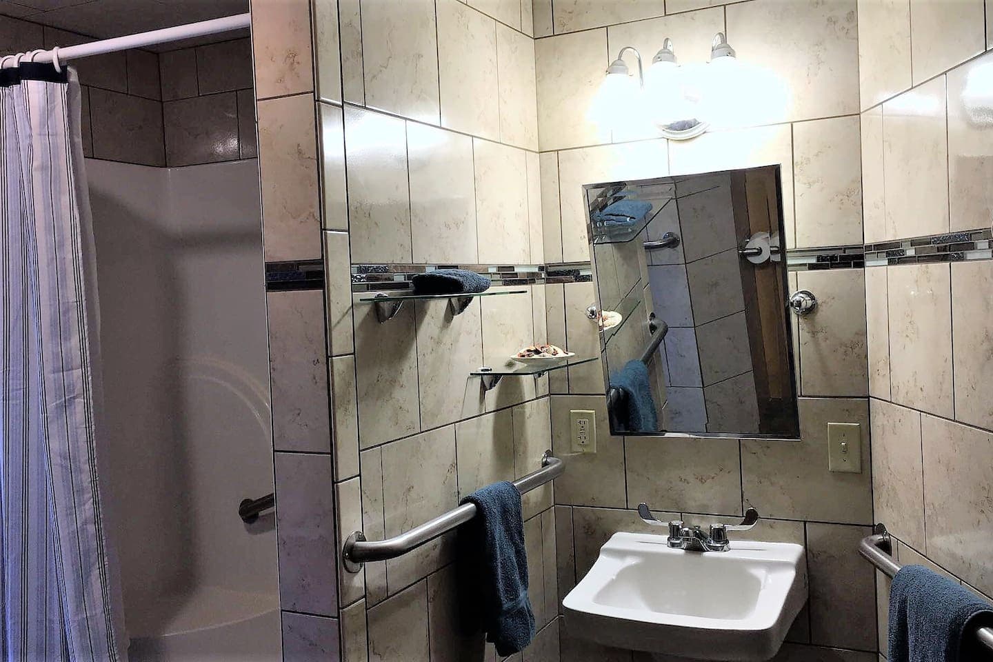 Handicapped accessible bathroom, fully tiled with stall shower