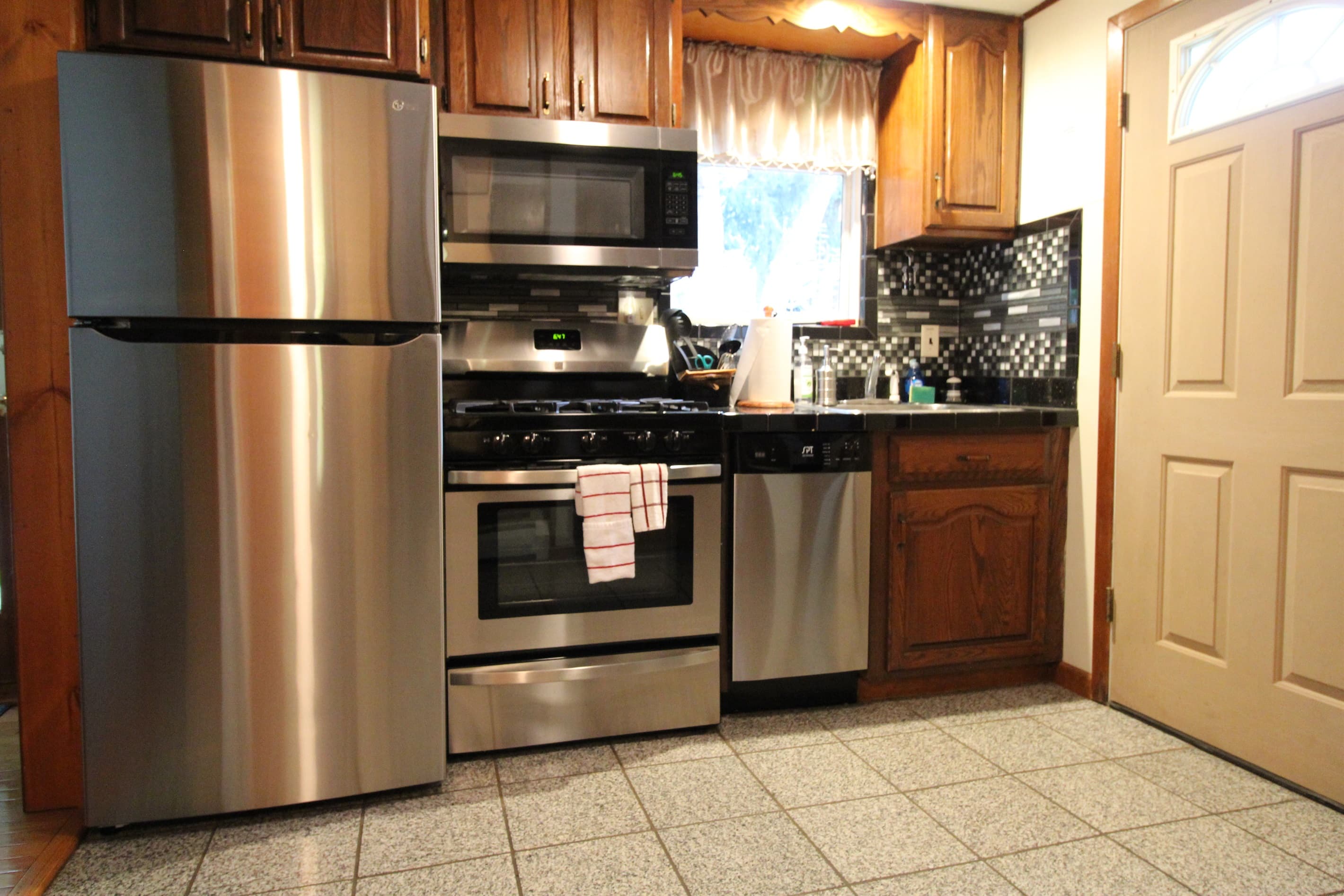 All Stainless Steel appliances with a newly tiled backsplash surround.