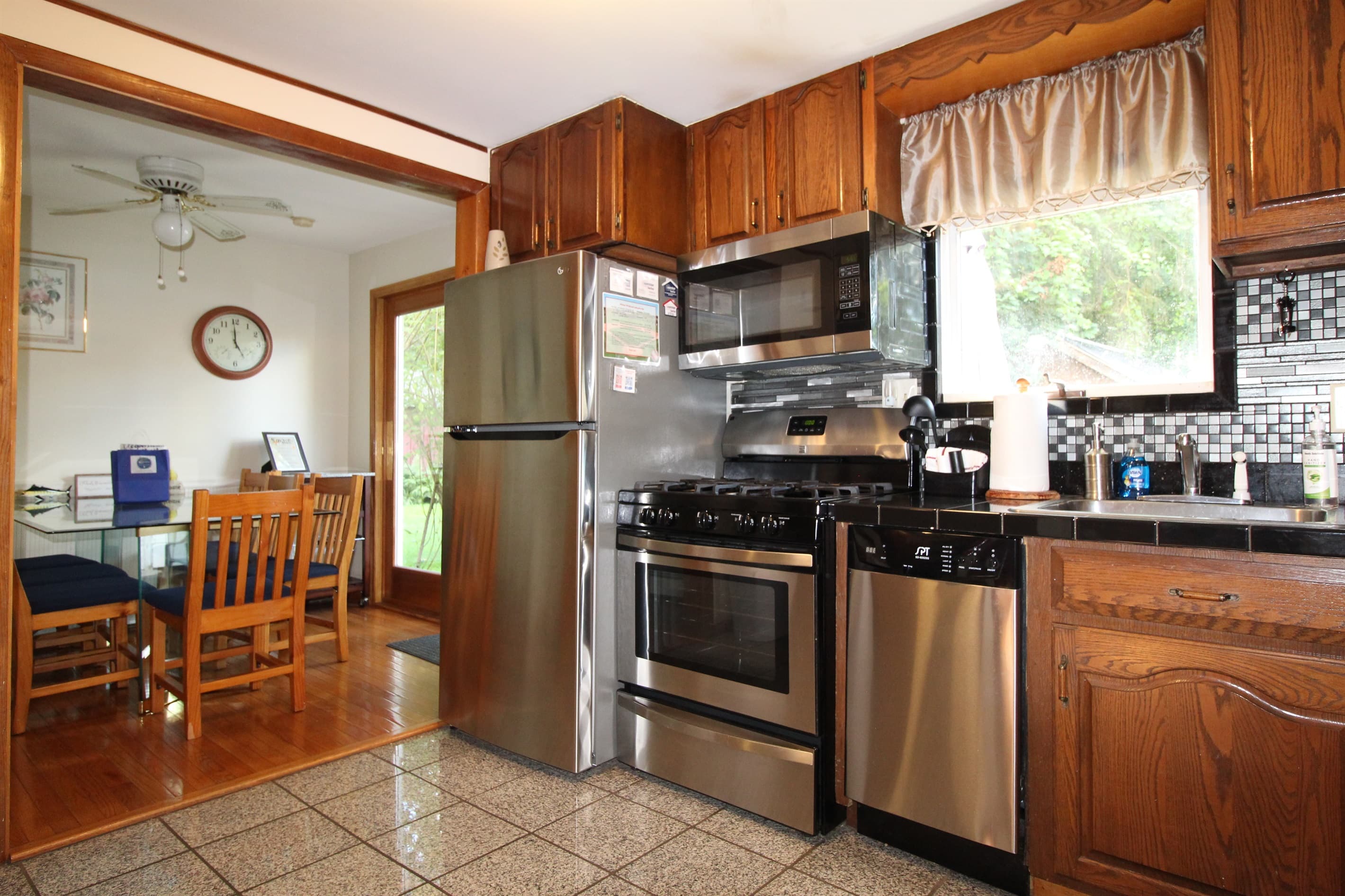 Kitchen with granite countertop and all stainless steel appliances.  Refrigerator has automatic ice maker to help create your favorite refreshing beverages.