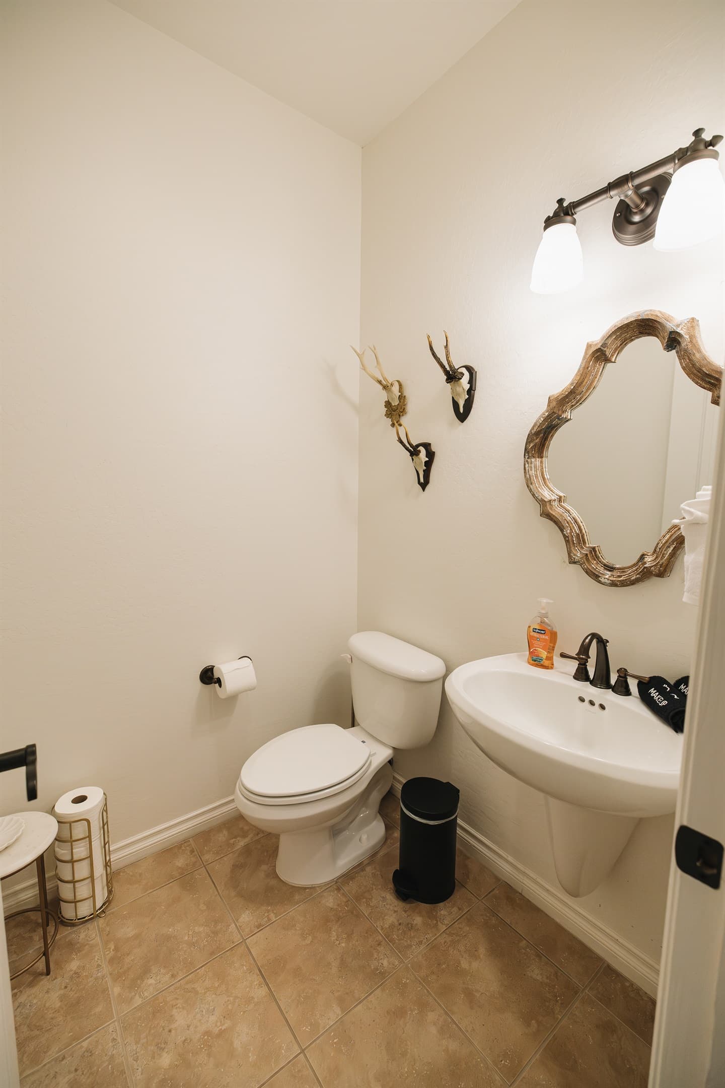 Clean, thoughtfully stocked half bath with warm lighting and elevated finishes—perfect for guests and easy convenience during your stay.