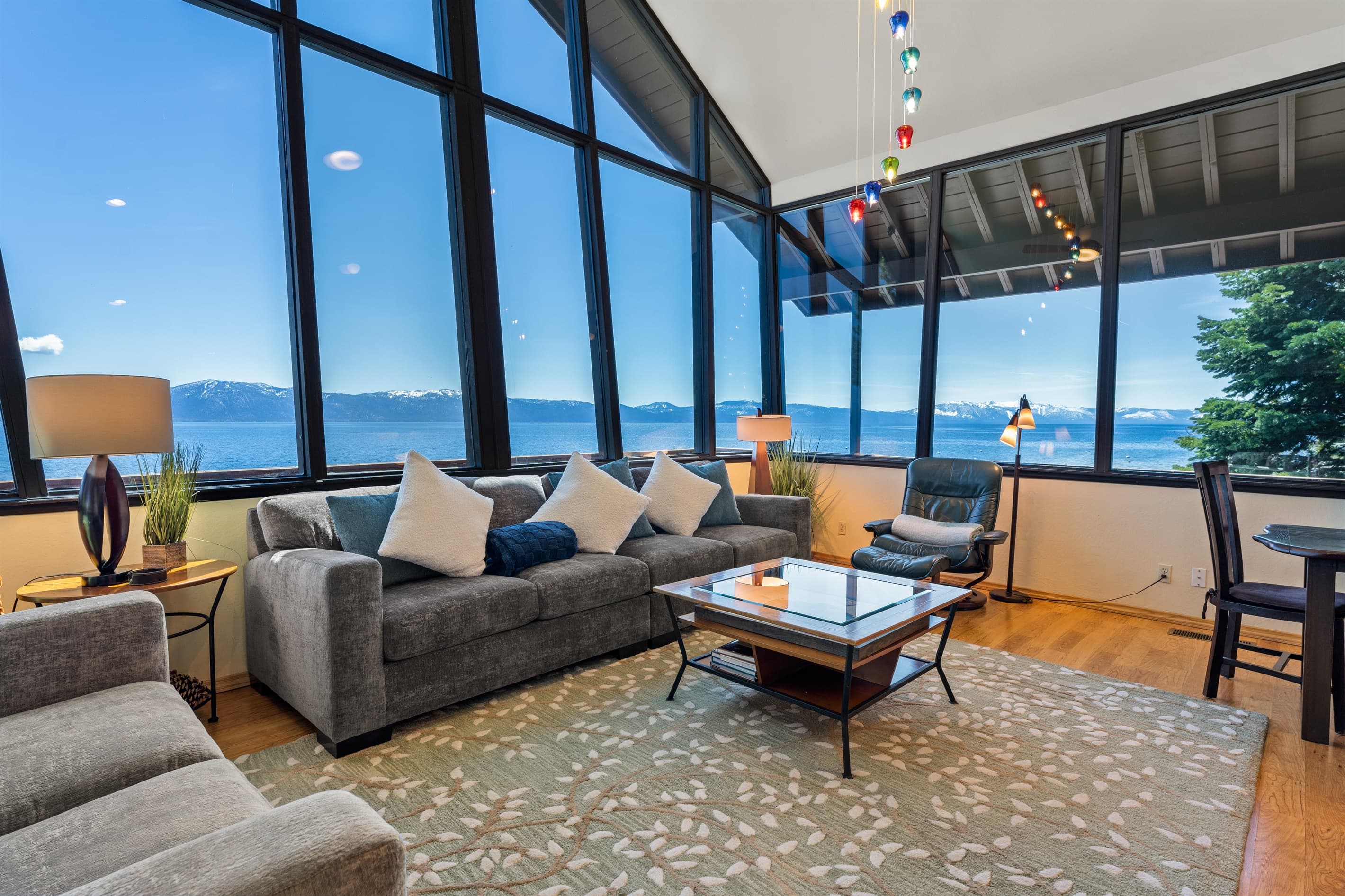 Enjoy panoramic Lake Tahoe views from the living room with floor-to-ceiling windows. Listen to the waves crash on the rocks below as you relax by the gas fireplace or watch your favorite shows on the smart TV.