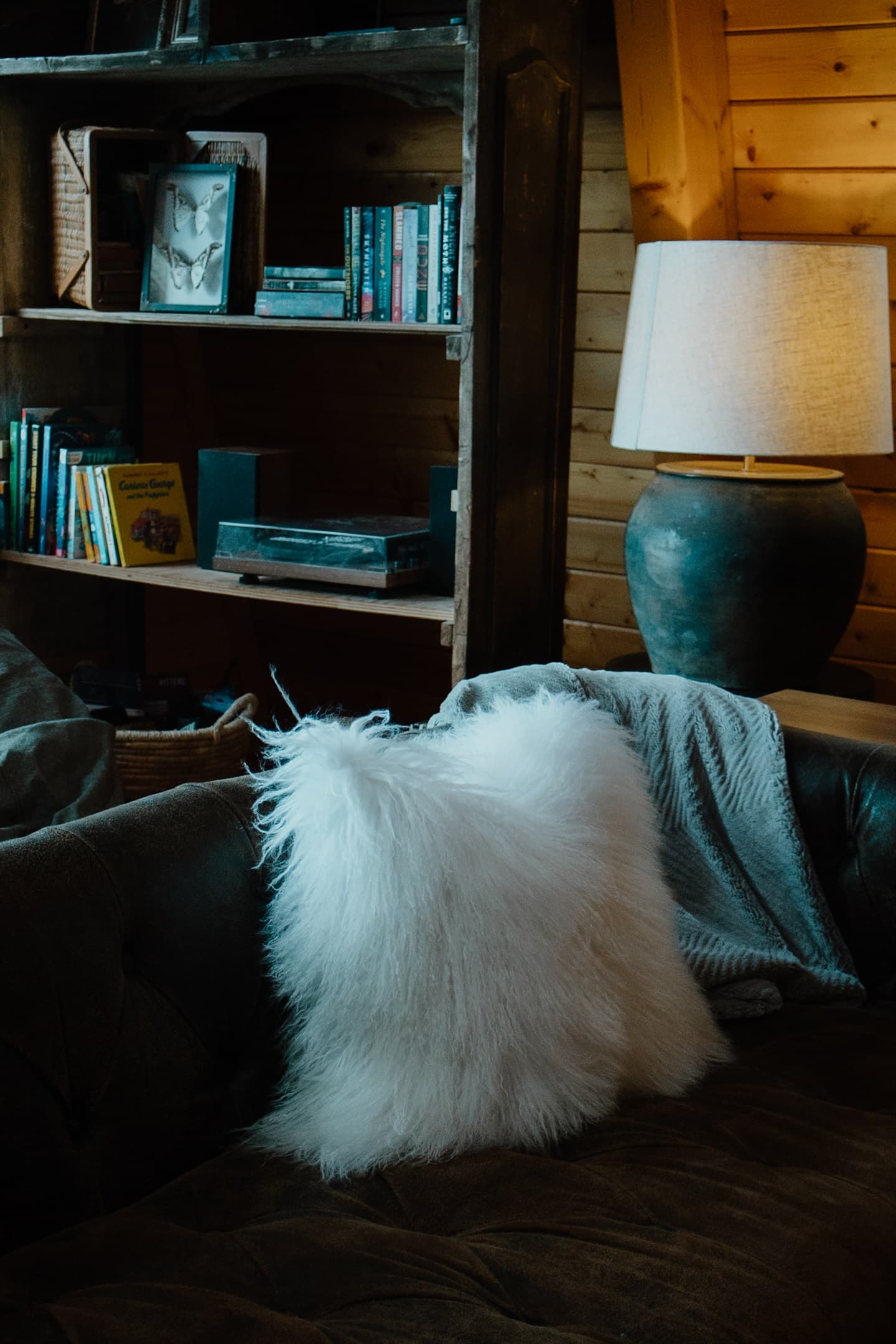 Curated mountain cabin details create a cozy reading nook with plush seating, warm wood walls, and soft textures. This A-frame retreat in Show Low is perfect for relaxing after hiking or enjoying a quiet White Mountains getaway.