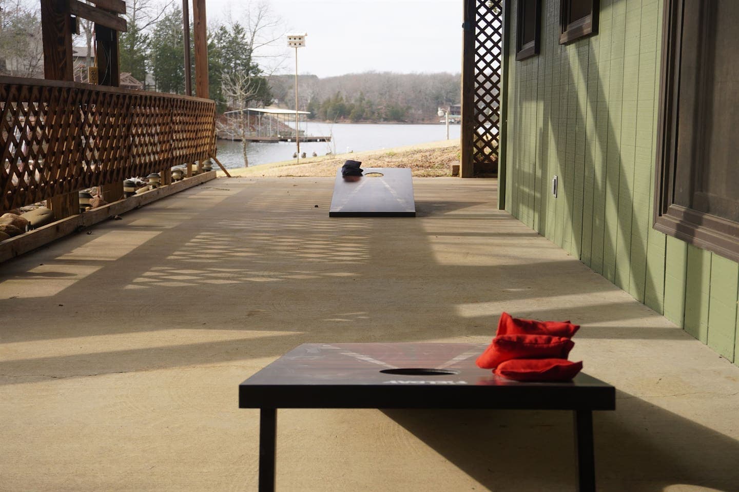 A deck with a table and red bean bag toss game: Enjoy outdoor fun with a deck setup featuring a table and a red bean bag toss game.