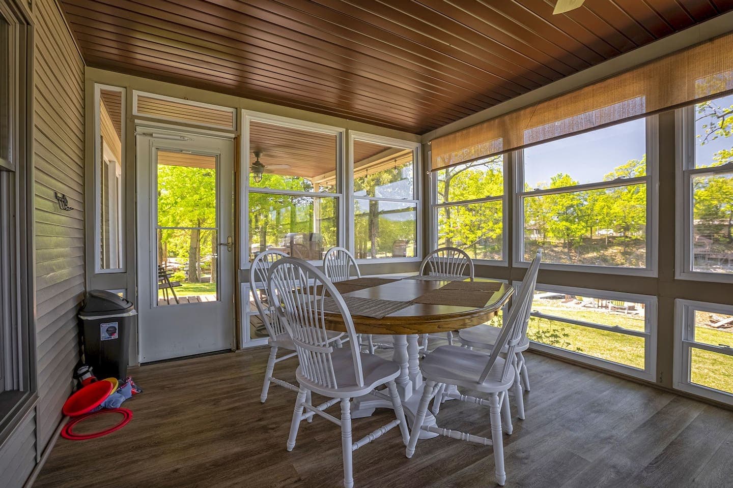 A cozy screened porch with a table and chairs, perfect for enjoying the outdoors in comfort.