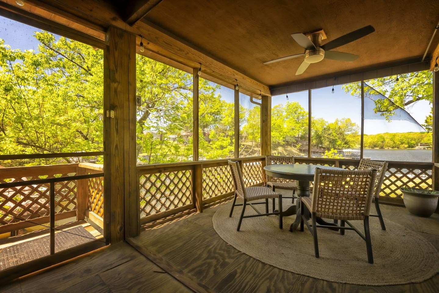 Screened porch with table and chairs, perfect for outdoor dining and relaxation.