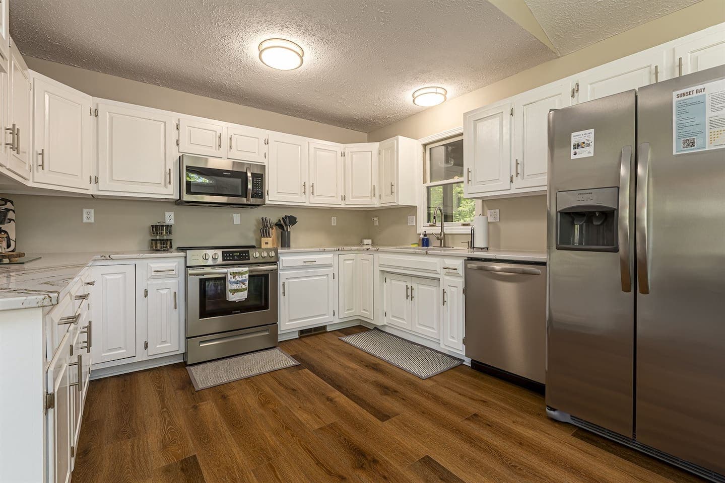 A modern kitchen with sleek stainless steel appliances and warm wood floors.
