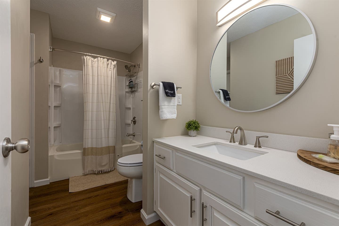 A bathroom with a white sink, toilet, and shower.
