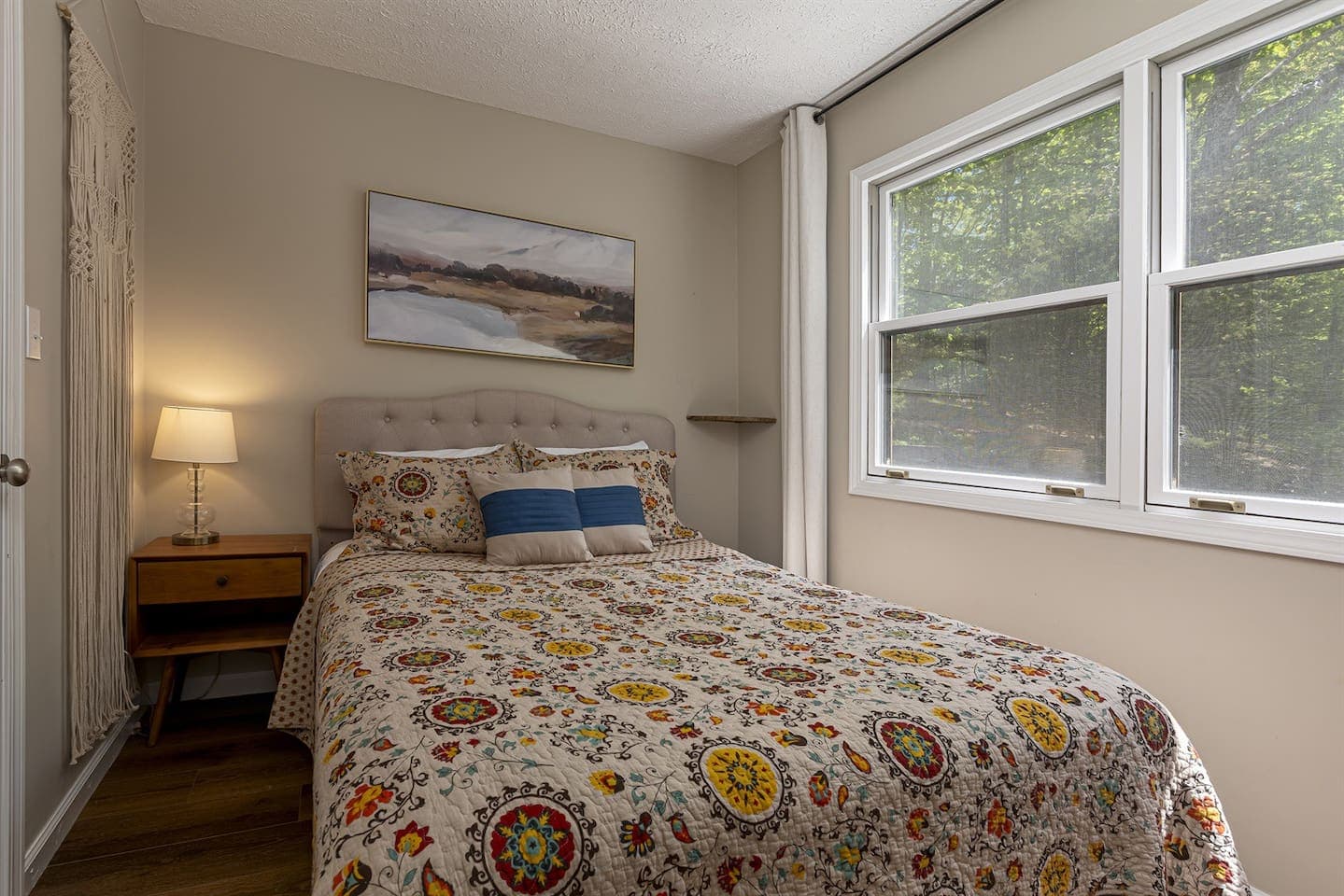 A cozy bedroom with a comfortable bed and a window offering a view of the outside world.