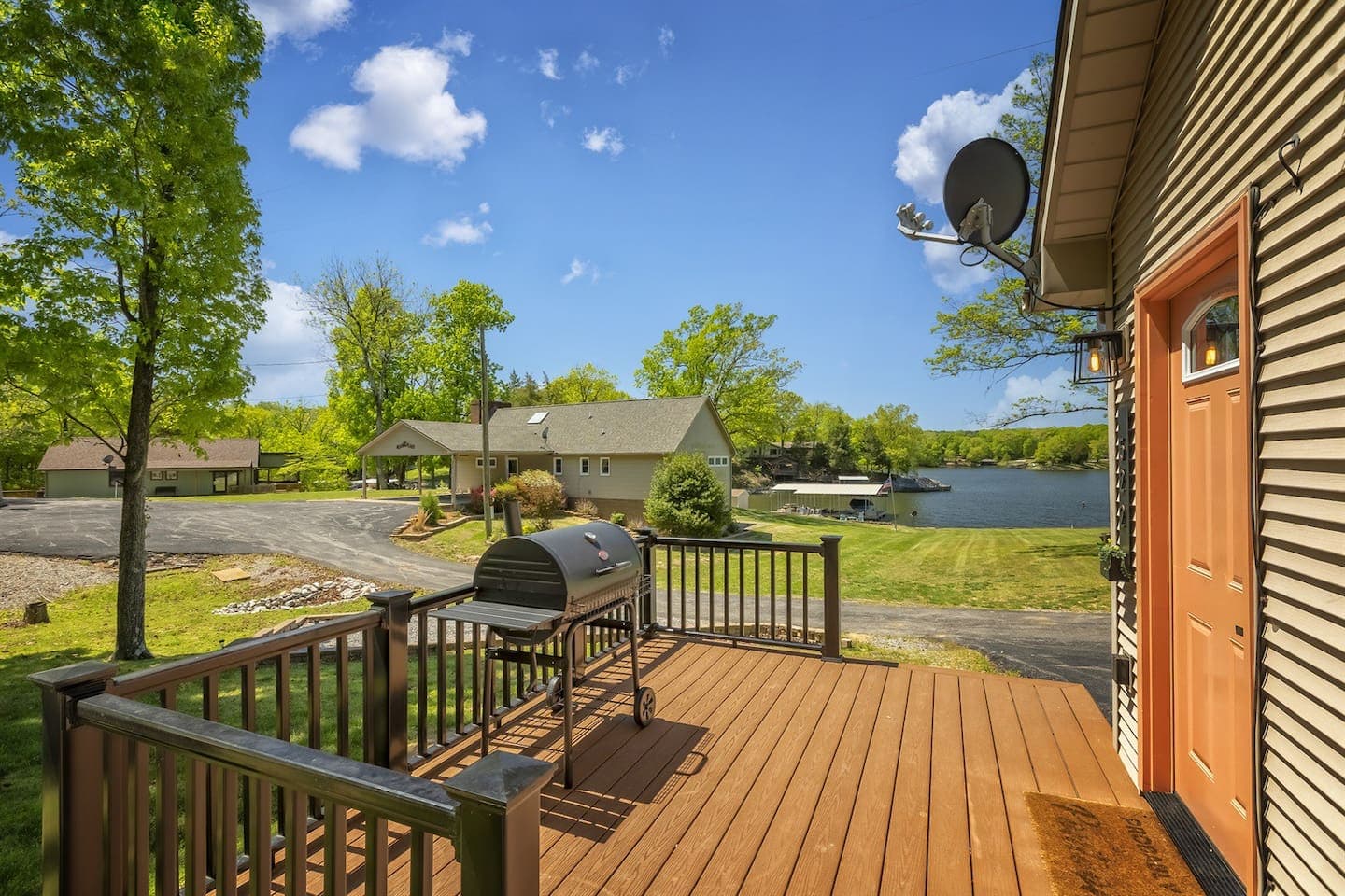 A lakeside deck with a grill, offering a picturesque view of the serene lake.