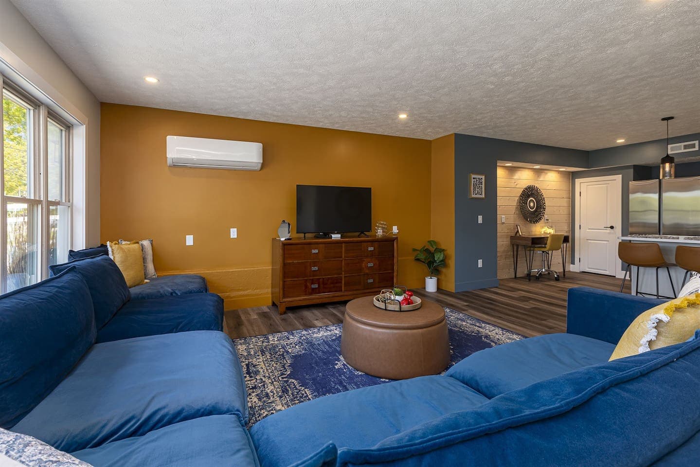 A cozy living room with blue couches and a TV.