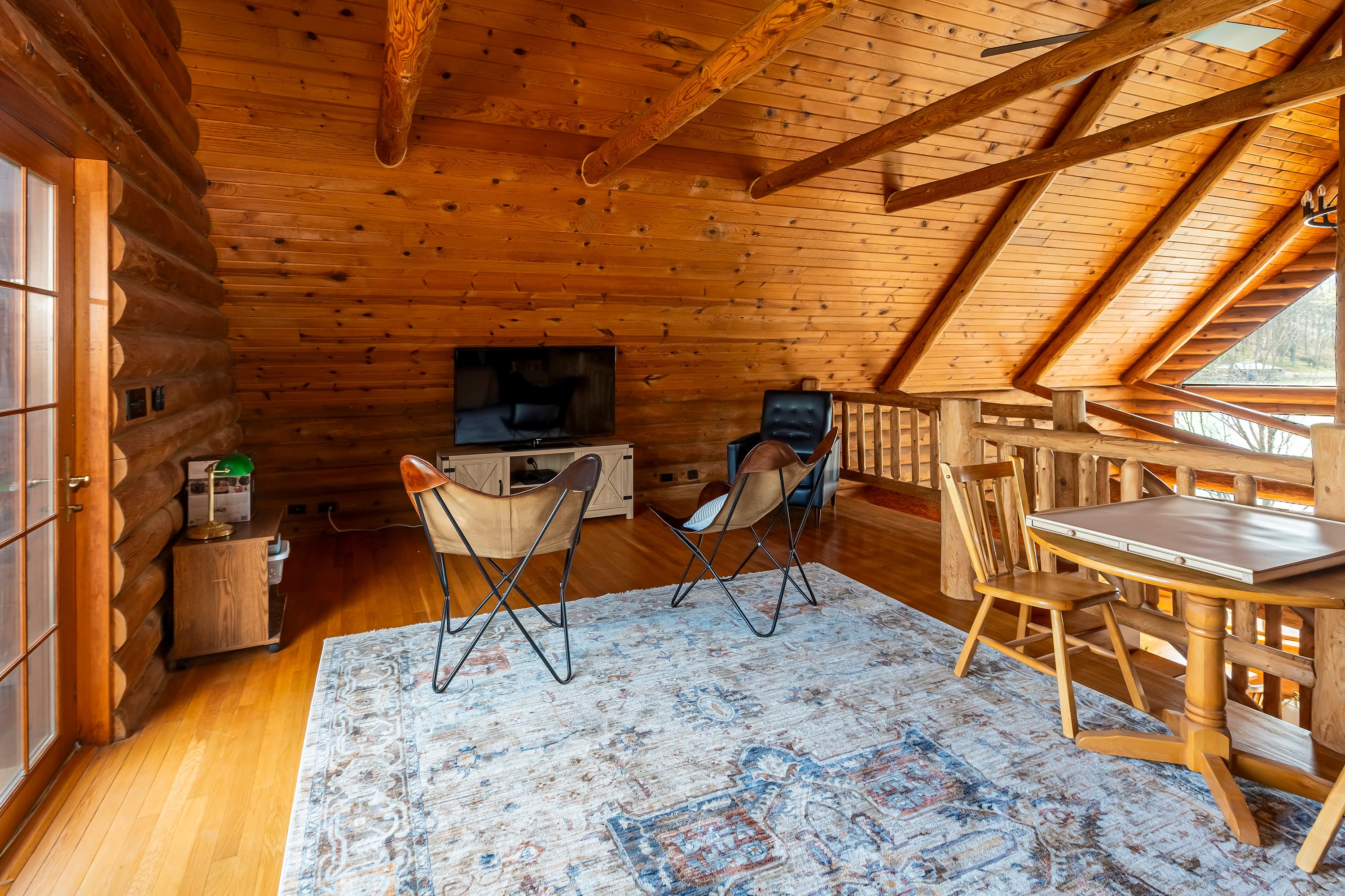 Loft has TV and table overlooking living room