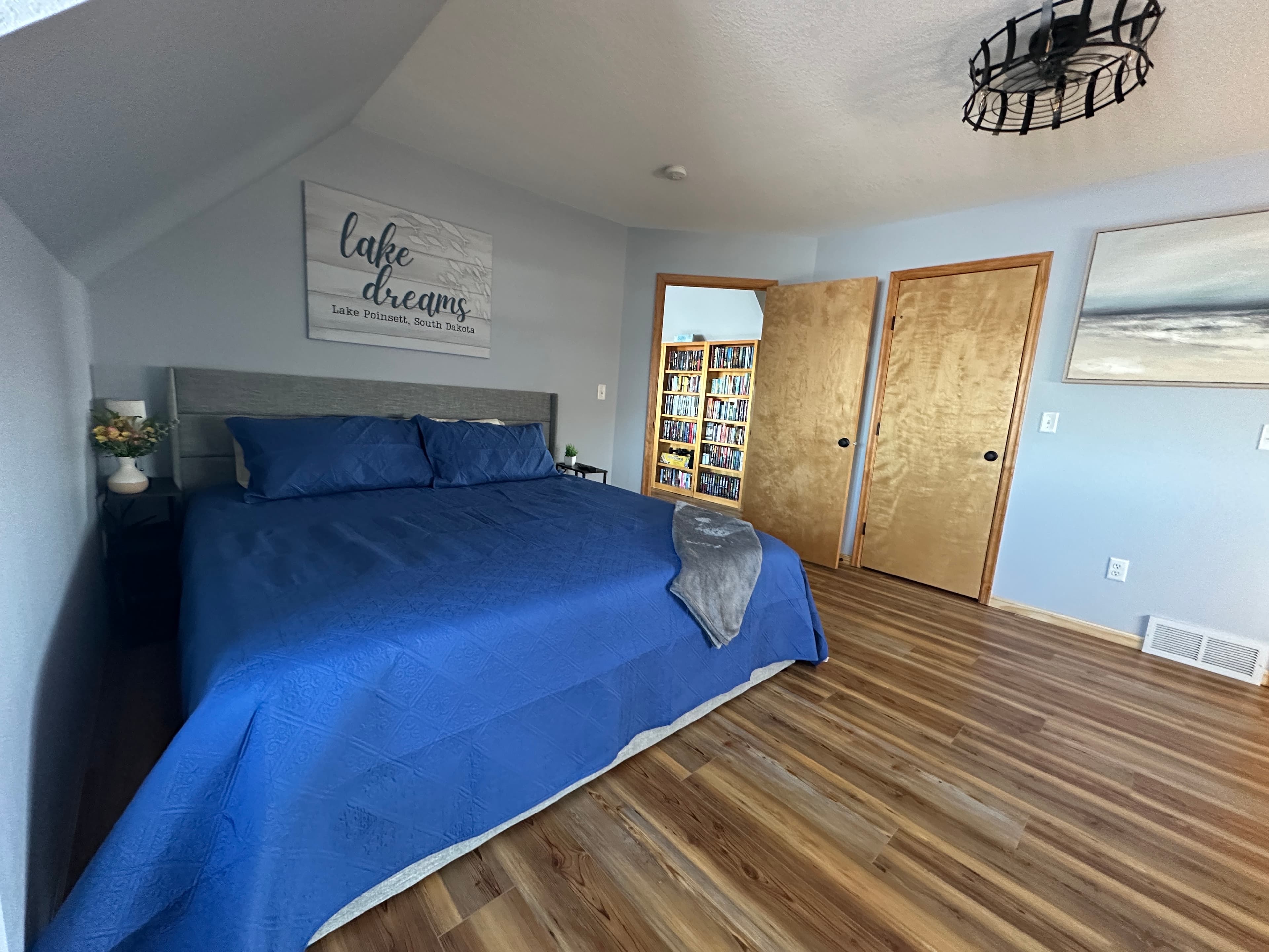 This spacious upstairs lakeside bedroom offers a king bed, futon, and a dedicated work space—designed for peaceful mornings, lake breezes, and staying connected when needed.