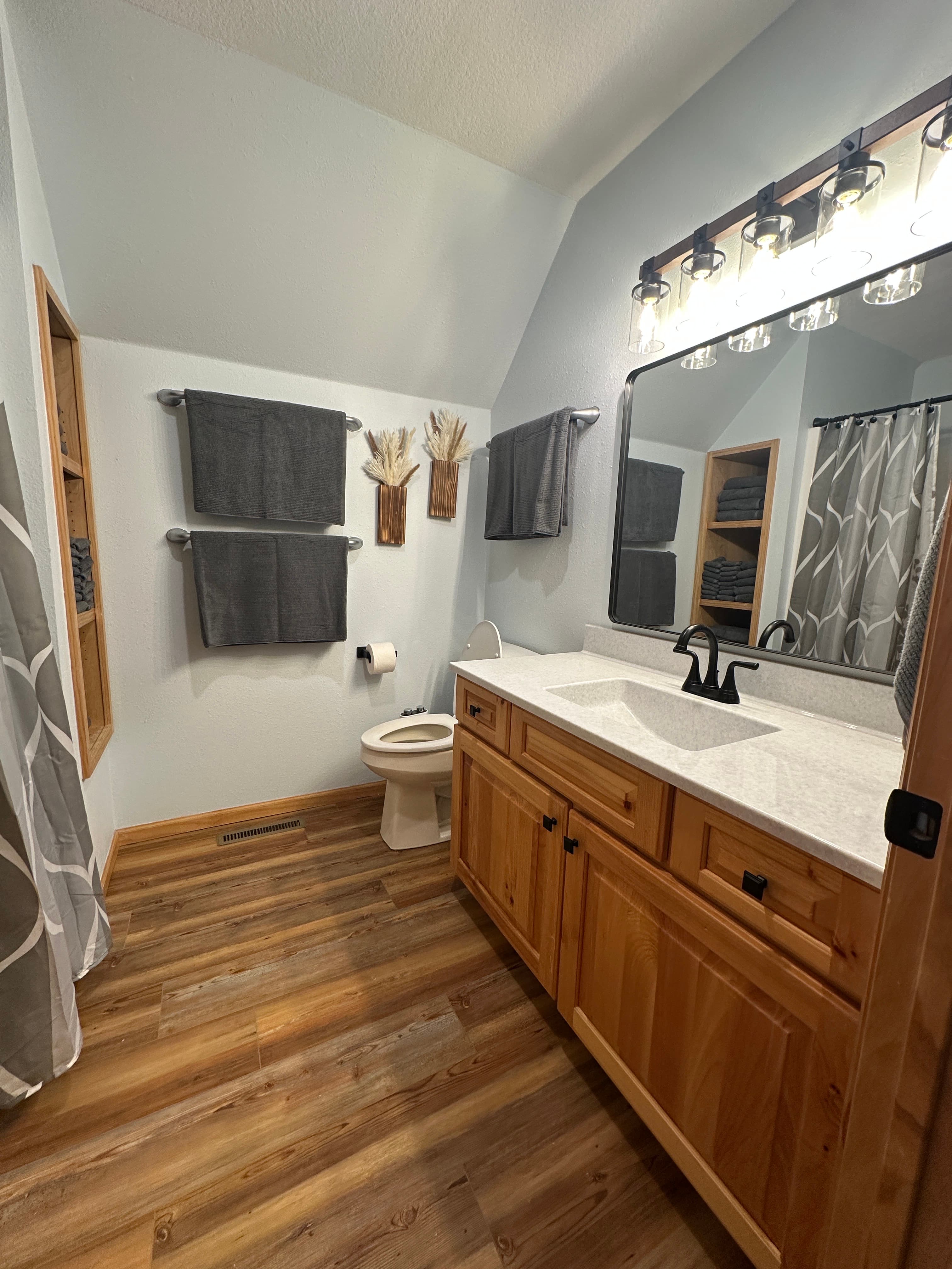 Bringing lakehouse charm indoors, the upgraded vanity pairs a smooth quartz top with modern black fixtures—clean, calming, and perfect after a day on the water.