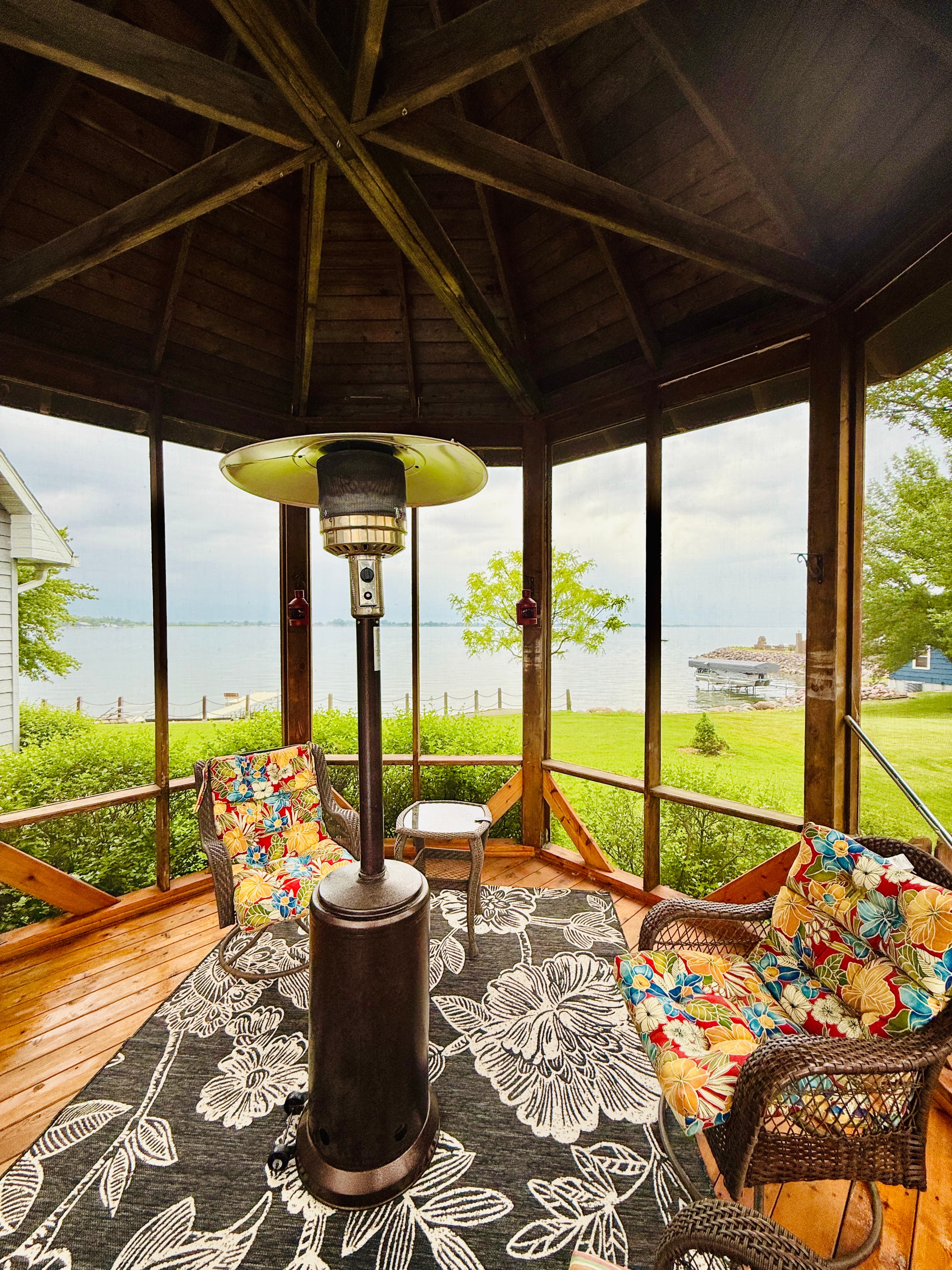 Step inside the screened gazebo for lakeside relaxation—comfy seating, breeze-blocked comfort, and endless water views.