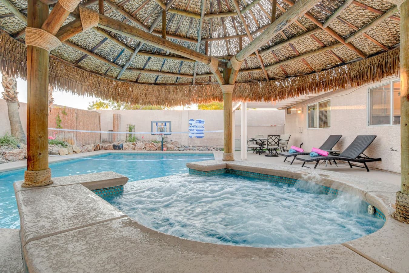 Resort-style pool and spa with shaded tiki hut and lounge chairs for ultimate comfort