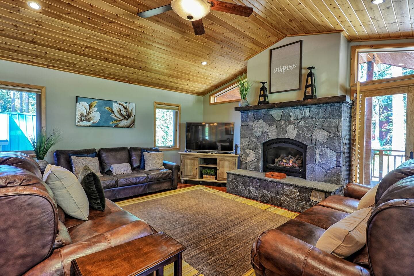 The rustic, but modern living room features comfortable seating and a cozy fireplace.