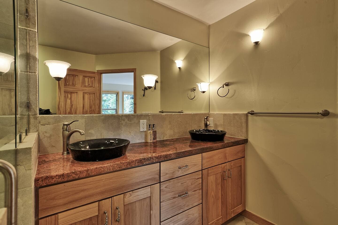 The primary bathroom has double raised bowl sinks, lots of counter space and plenty of storage.