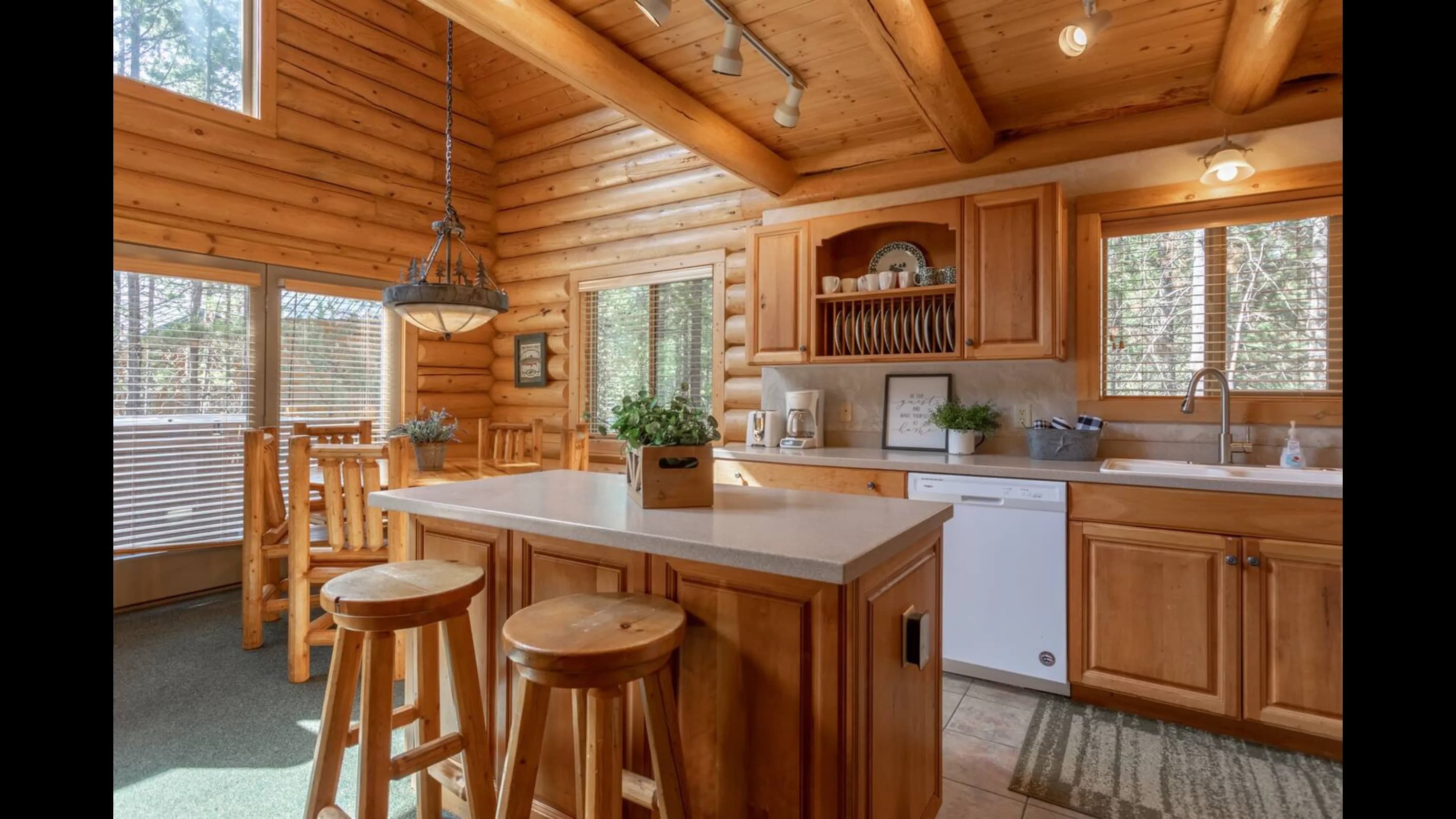 The kitchen features wooden cabinets, modern appliances, and a cozy dining space with bar stools.