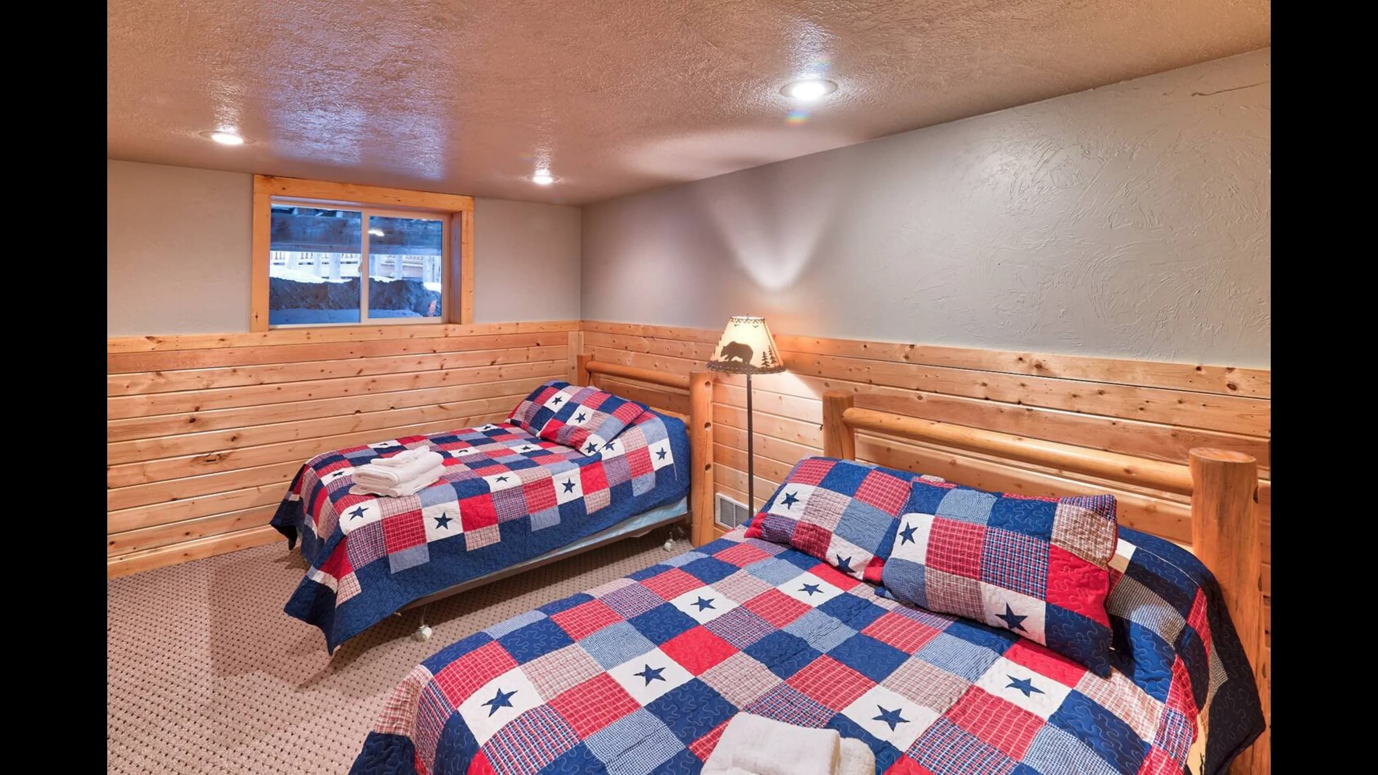 Bedroom 1:  Enhanced by wooden headboards, rustic quilts, soft carpeting, and gentle lighting, this room promises relaxation and comfort.