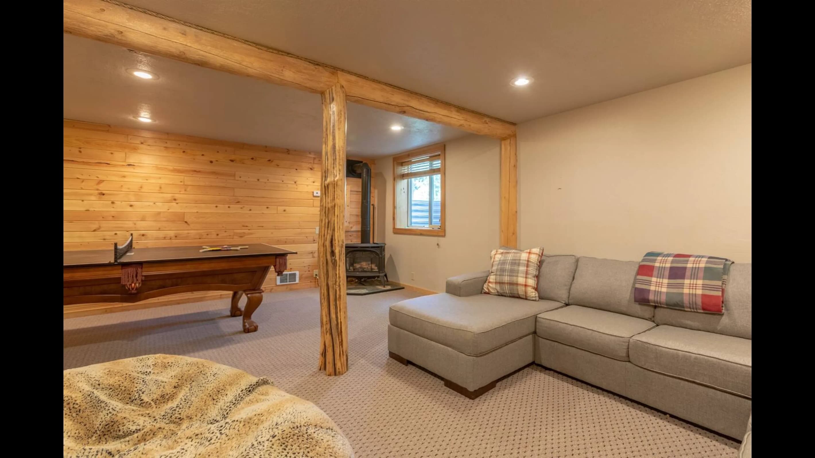 Bask in the cozy warmth of this room, adorned with wooden walls and a carpeted floor, ideal for both relaxation and play.