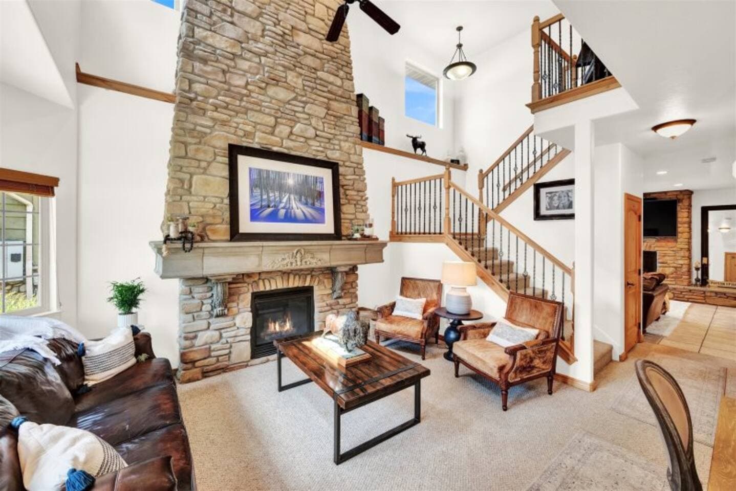 Spacious living room with vaulted ceilings, a leather sectional, and a cozy gas fireplace.