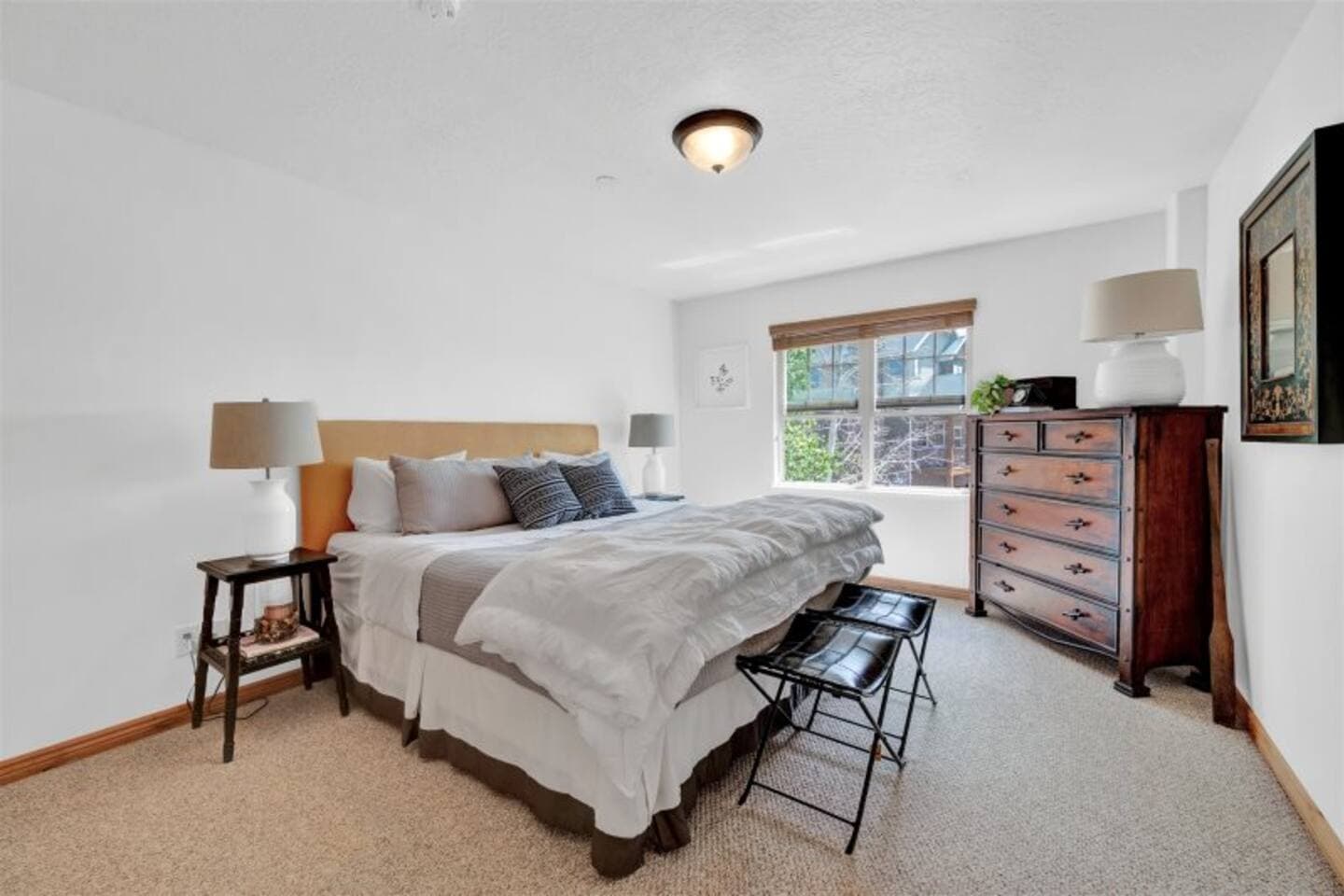 Spacious top-floor bedroom featuring a queen bed, dresser, and closet.