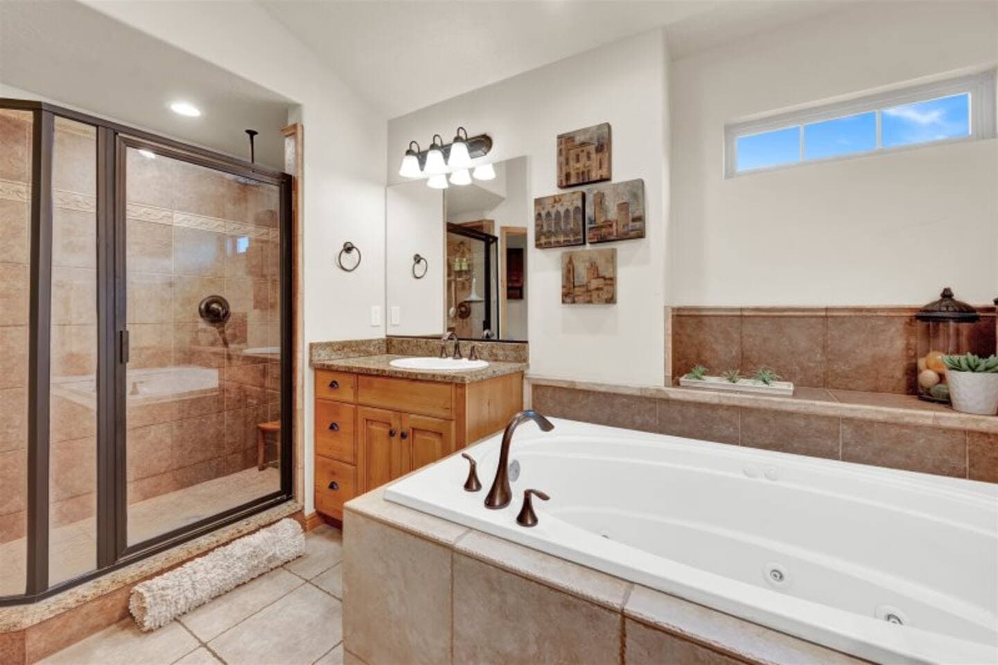 Spa-like primary bathroom featuring a deep soaker jetted  tub, a walk-in glass shower, and double vanities.