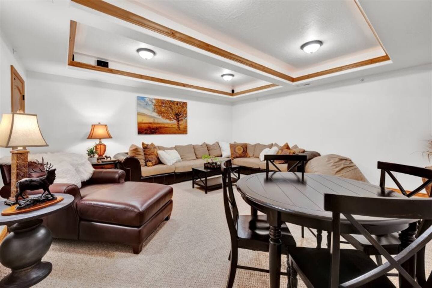 The entertainment room features a large TV, comfortable sectional for lounging, and a game table—perfect for movie nights, casual games, or just relaxing with friends and family.