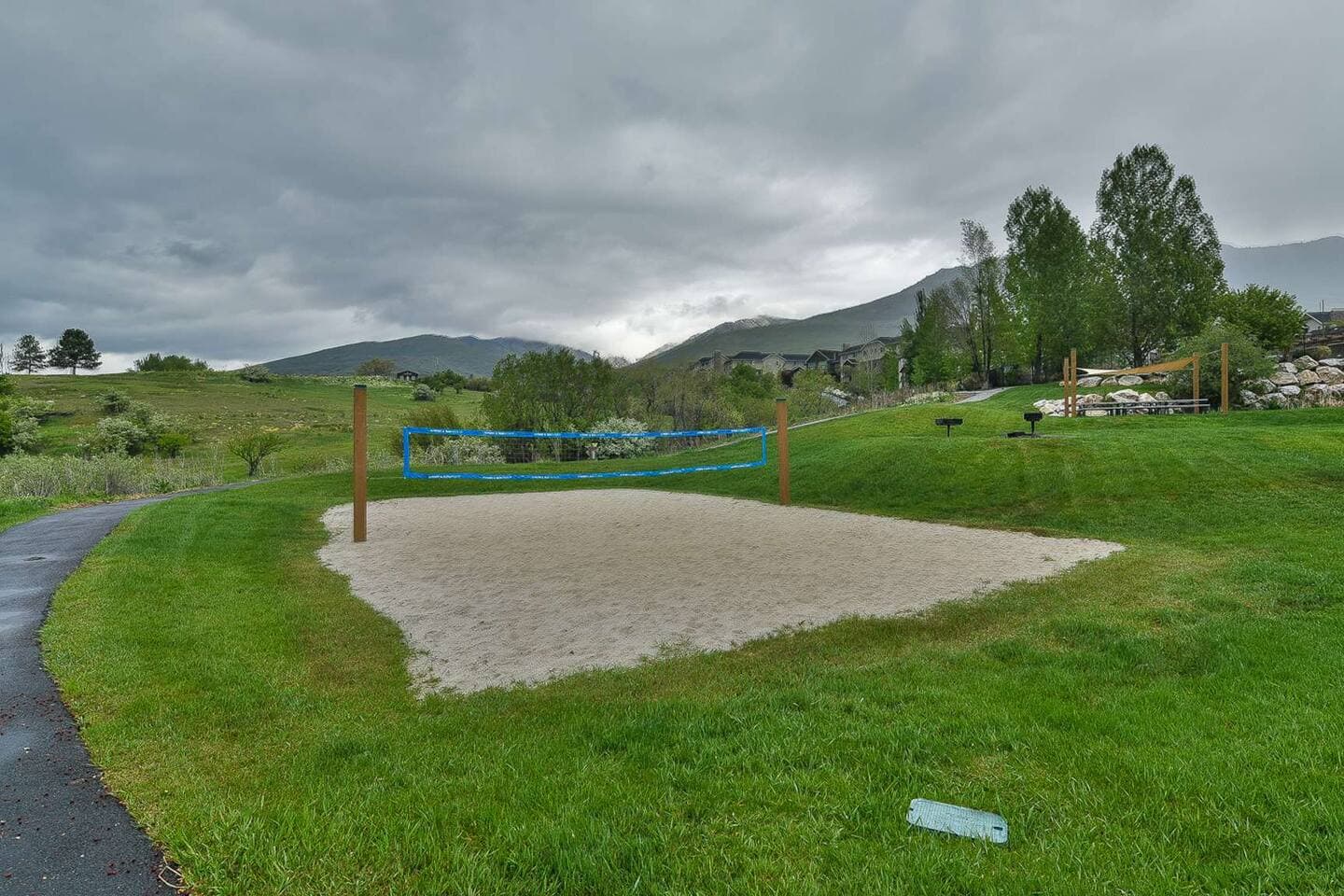 Enjoy a game on the community sand volleyball court, set against a scenic mountain backdrop. 