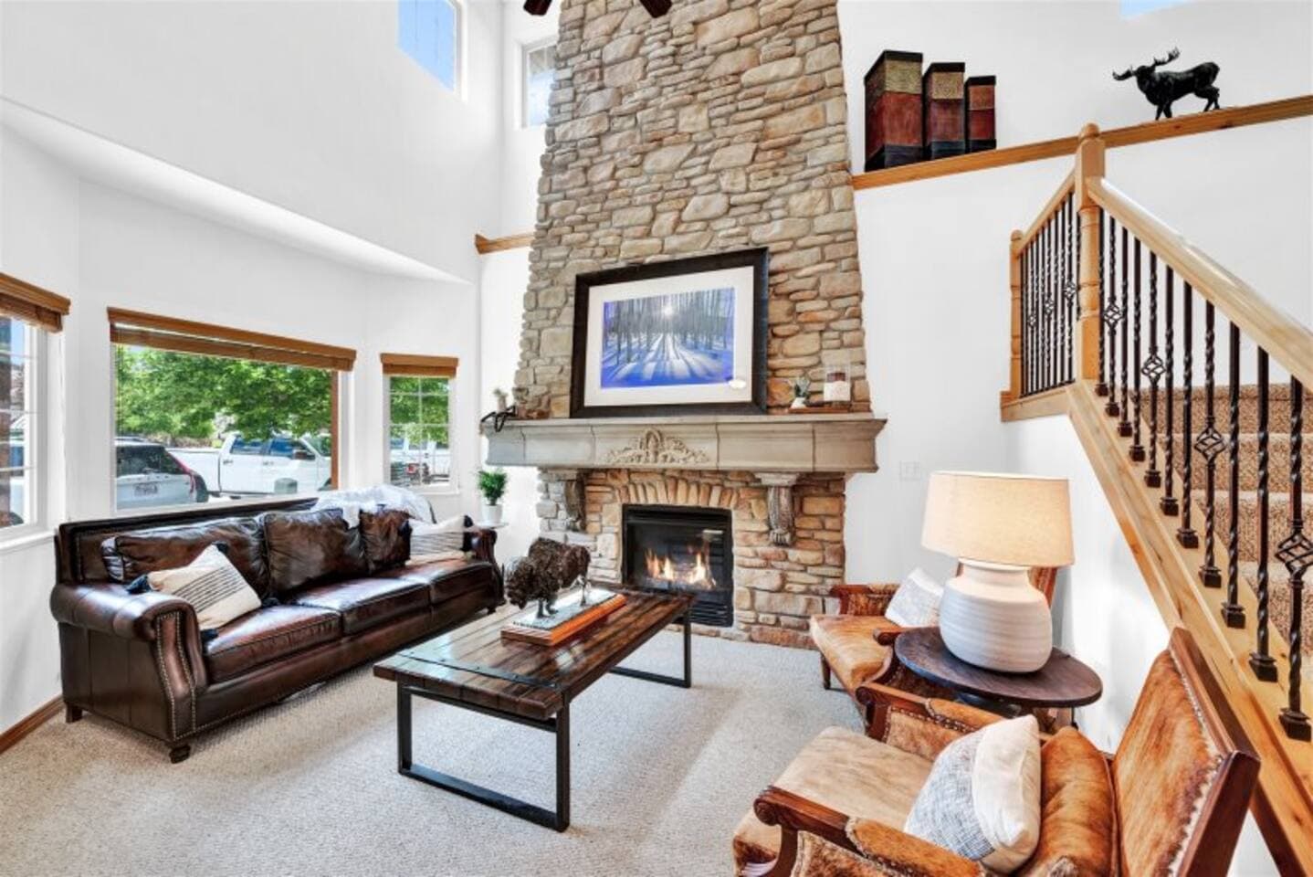 Spacious living room with soaring vaulted ceilings, a plush leather sectional, and a cozy gas fireplace—perfect for relaxing after a day of adventure.