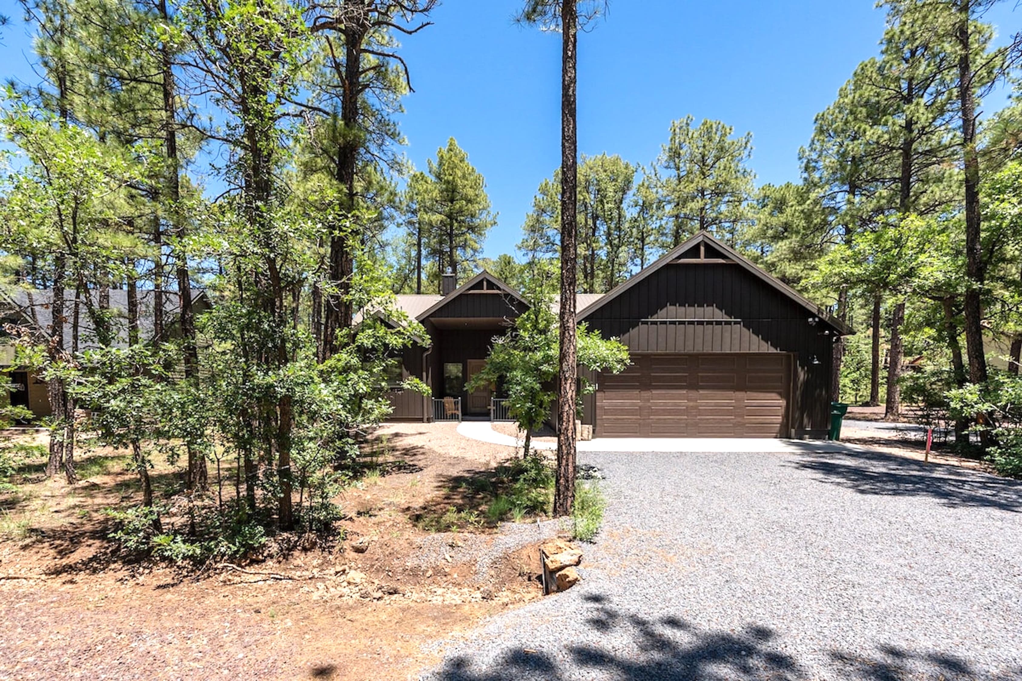 Nestled among towering pines, this charming home welcomes you with a spacious driveway and the quiet beauty of the forest all around.