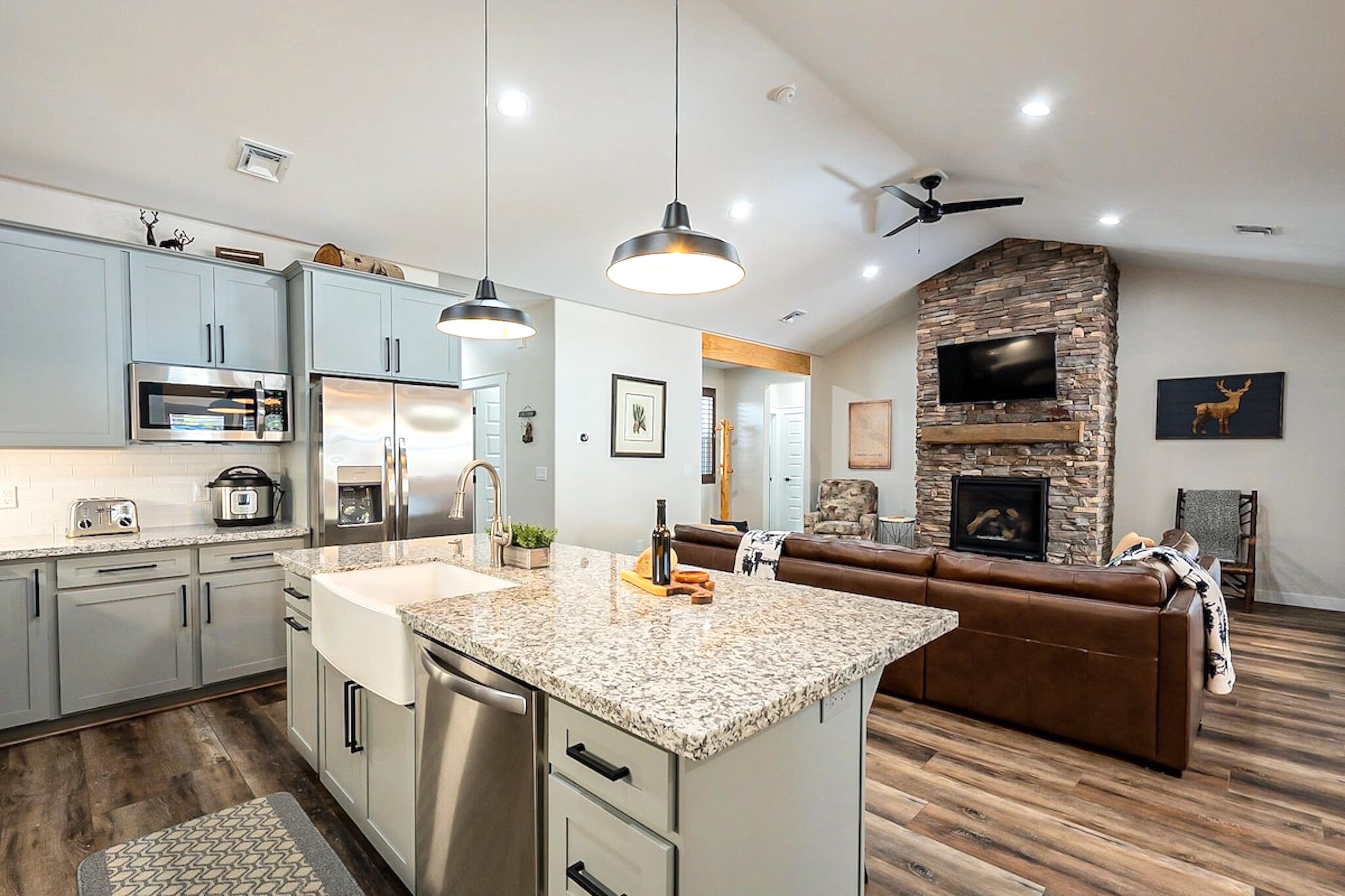 The kitchen island flows effortlessly into the living space, where the crackling fireplace sets the perfect backdrop for gatherings filled with warmth, conversation, and comfort.