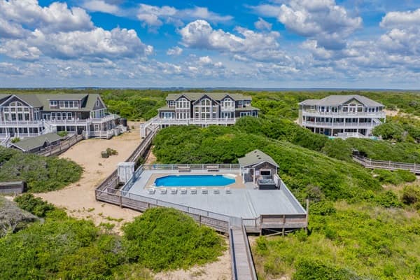 The Hemingway Exterior at Twilight — Illuminated Oceanfront Home with Multi-Level Decks | Corolla, Outer Banks
