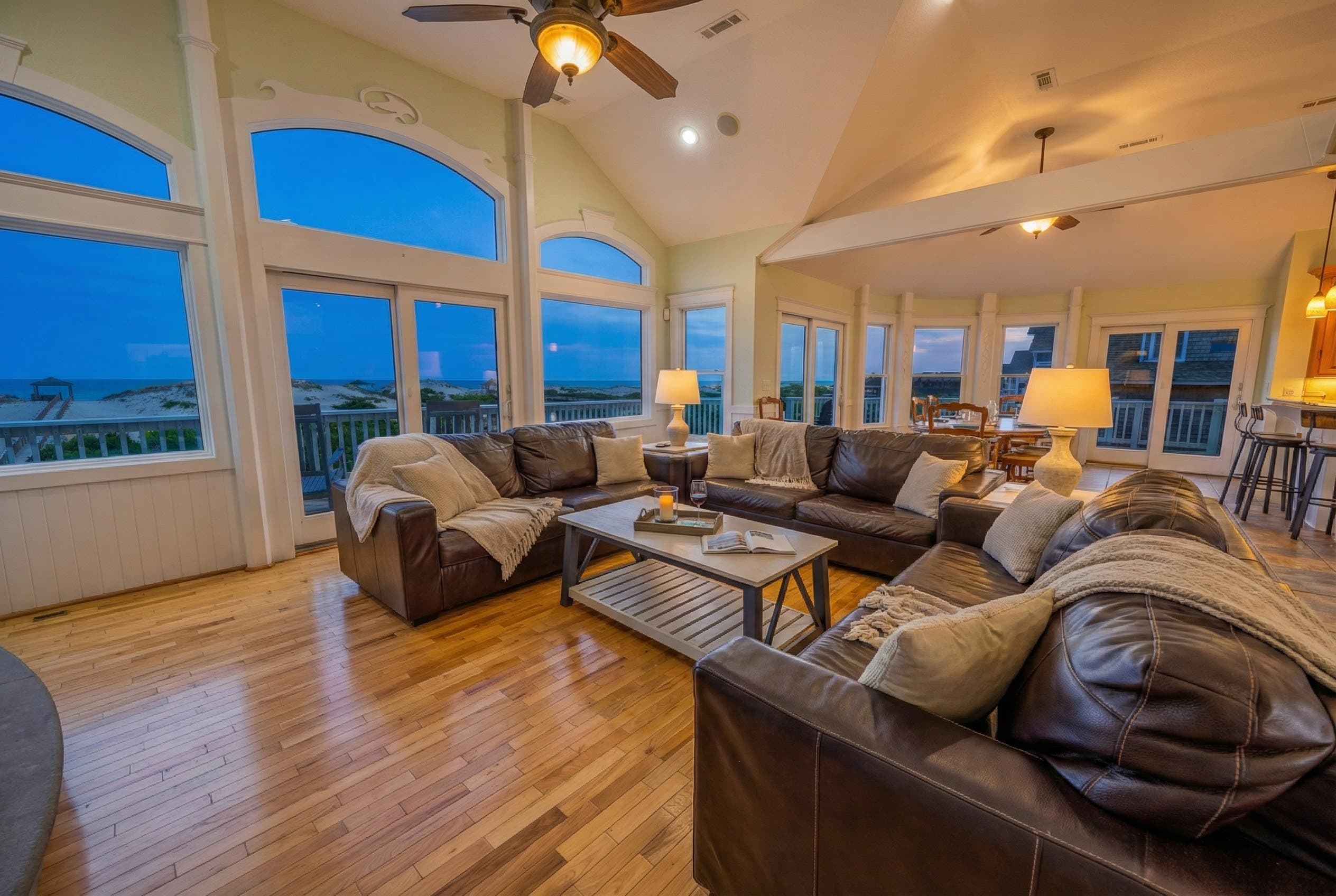 Open-concept living room designed for gathering — comfortable luxury seating with seamless flow to dining and oceanfront decks