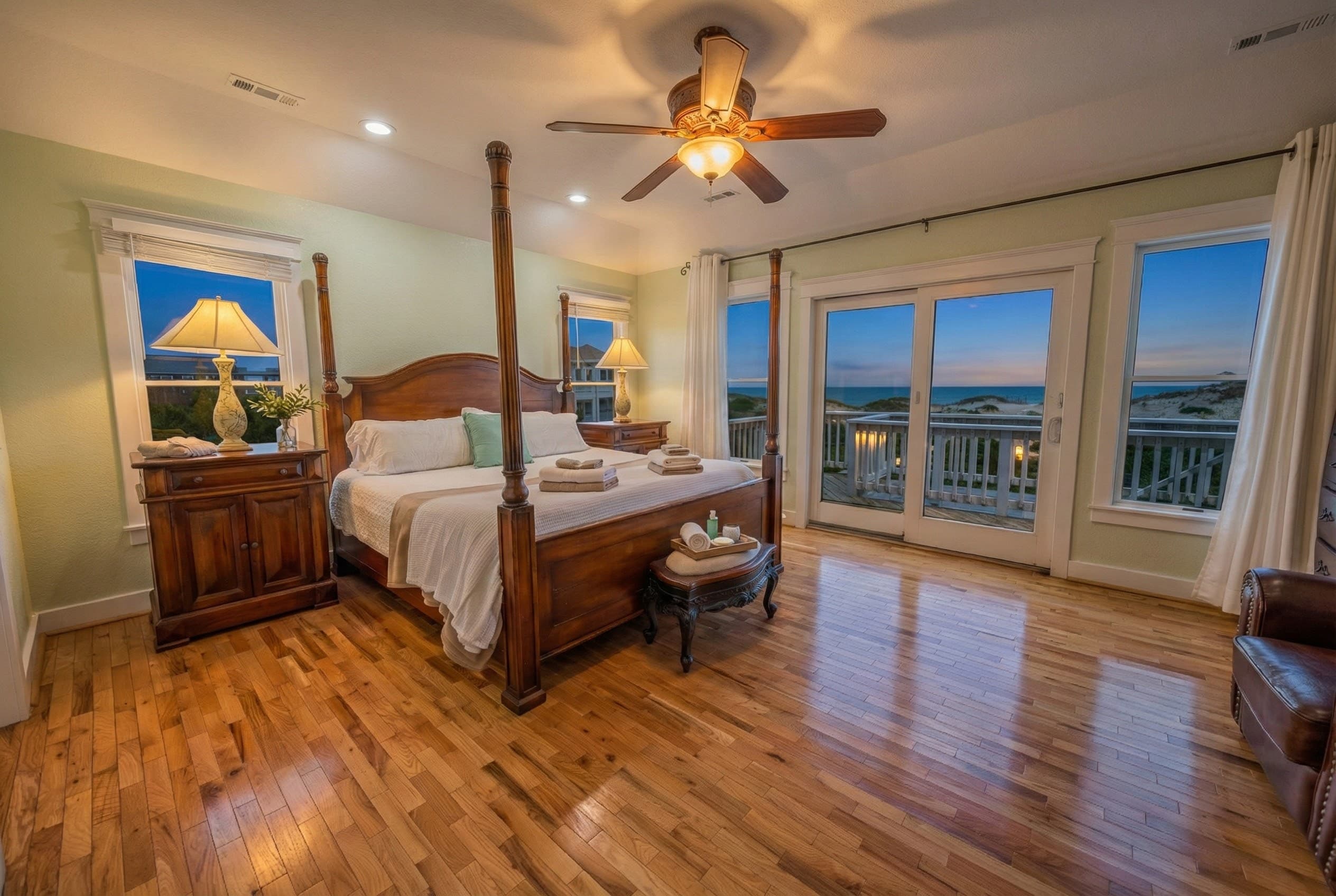 Primary king suite — luxurious bedding, serene coastal palette, and ocean breezes for an indulgent night's rest