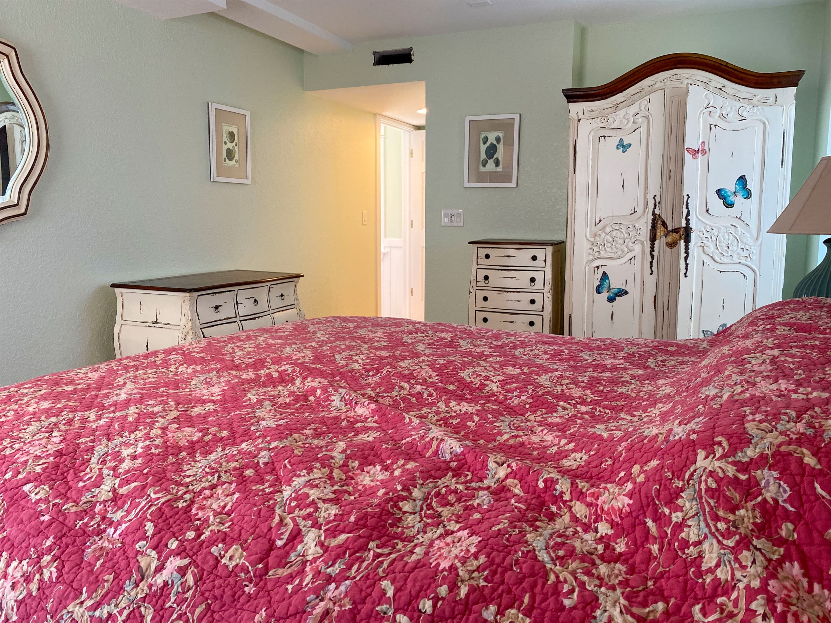Charming bedroom with coastal pink accents — quality bedding and artistic decor for a delightful restful experience