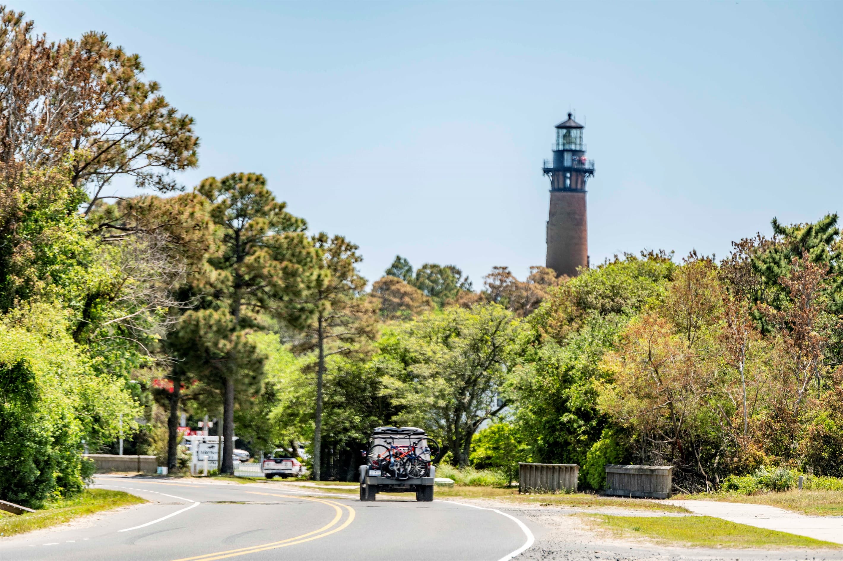 Lighthouse approach with scenic roadway — the iconic Corolla landmarks are moments from your private estate