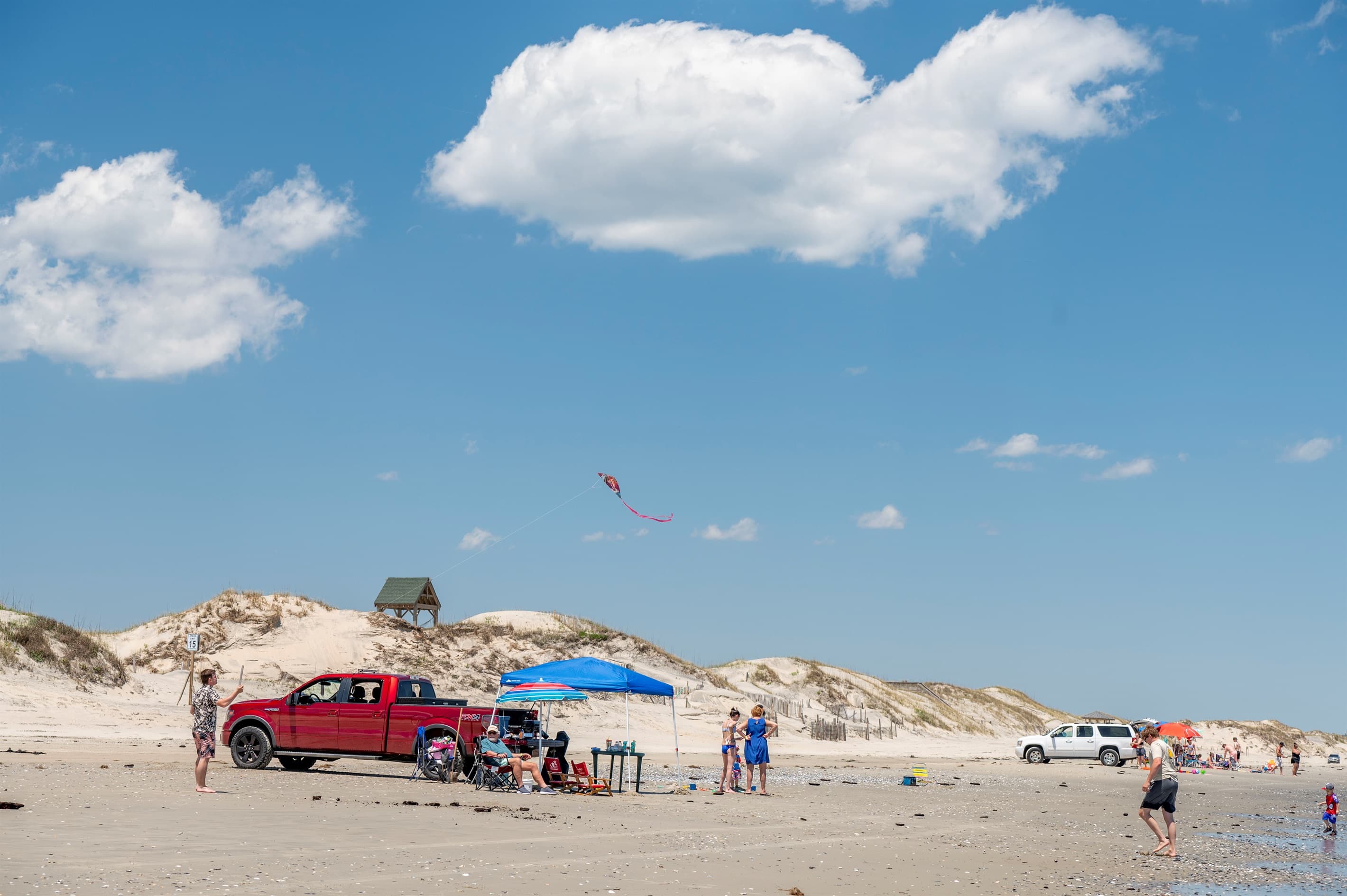 Beach scene with colorful umbrellas — the vibrant energy of an Outer Banks summer steps from the estate