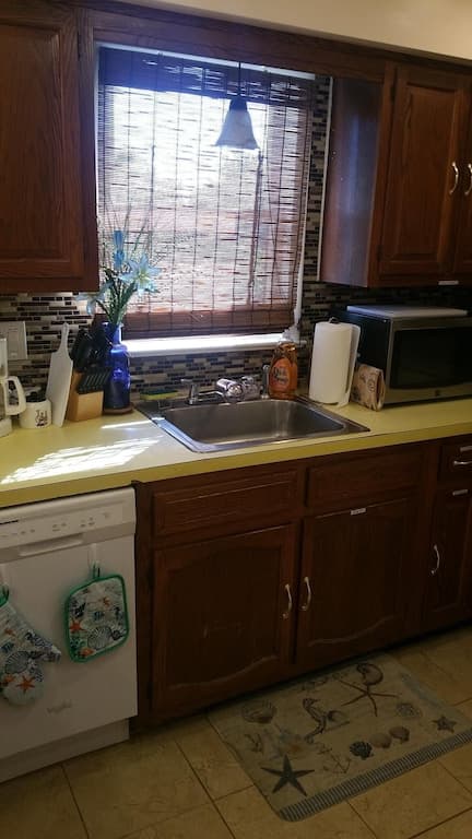 View of large sink area. Contains disposal, trash bags, small fire extinguisher, etc.