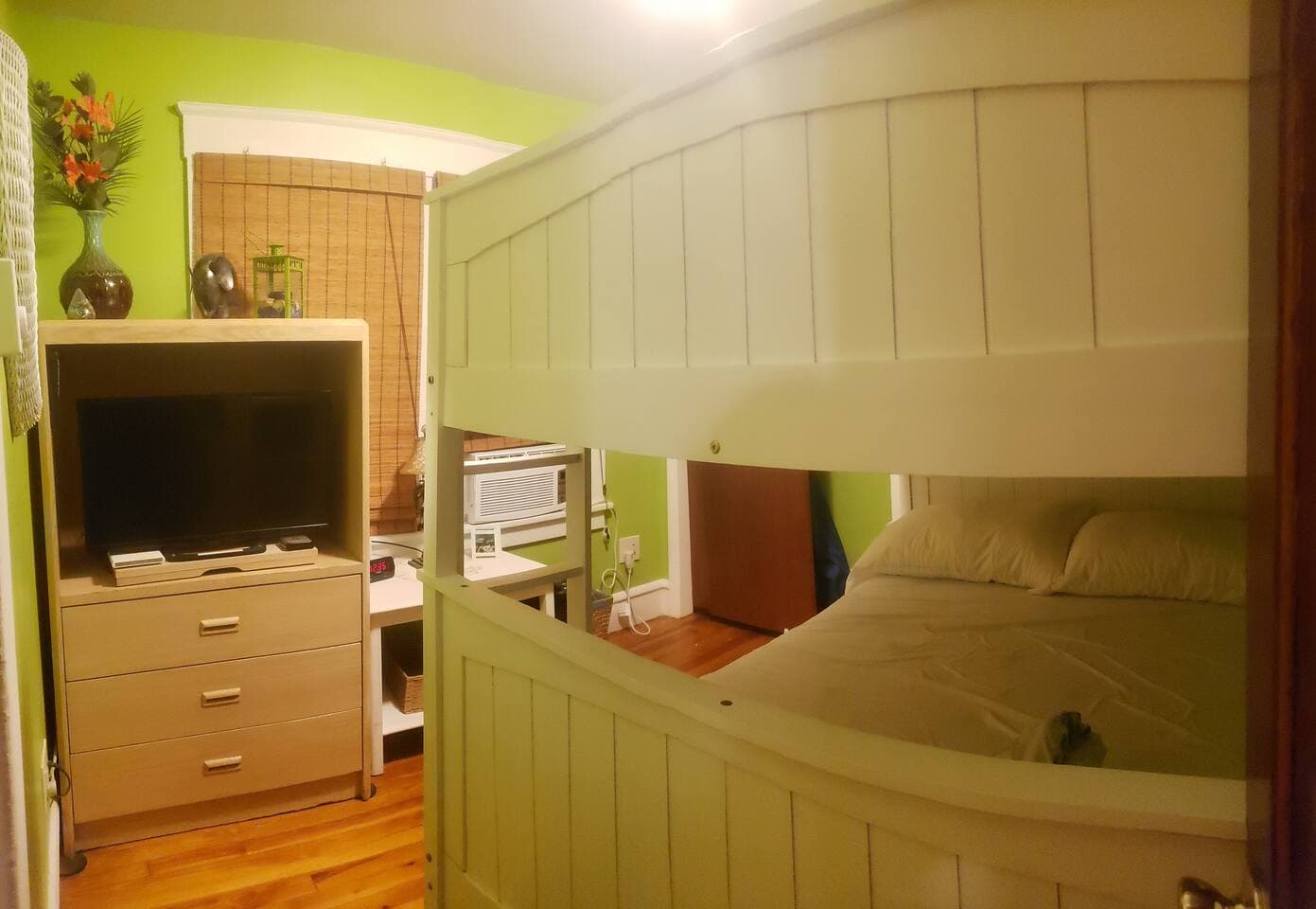 Middle Bedroom has been dubbed the Tropical Oasis. Each room has big flat screen TVs. Both this one and back bedroom are Smart TVs.