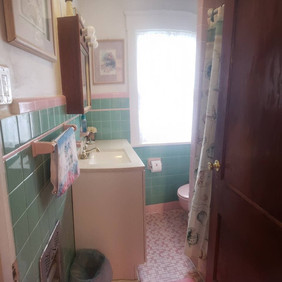 Small yet functional vintage Mamie Eisenhower bathroom!  Shower/tub combo. Large vanity w/extra storage. 