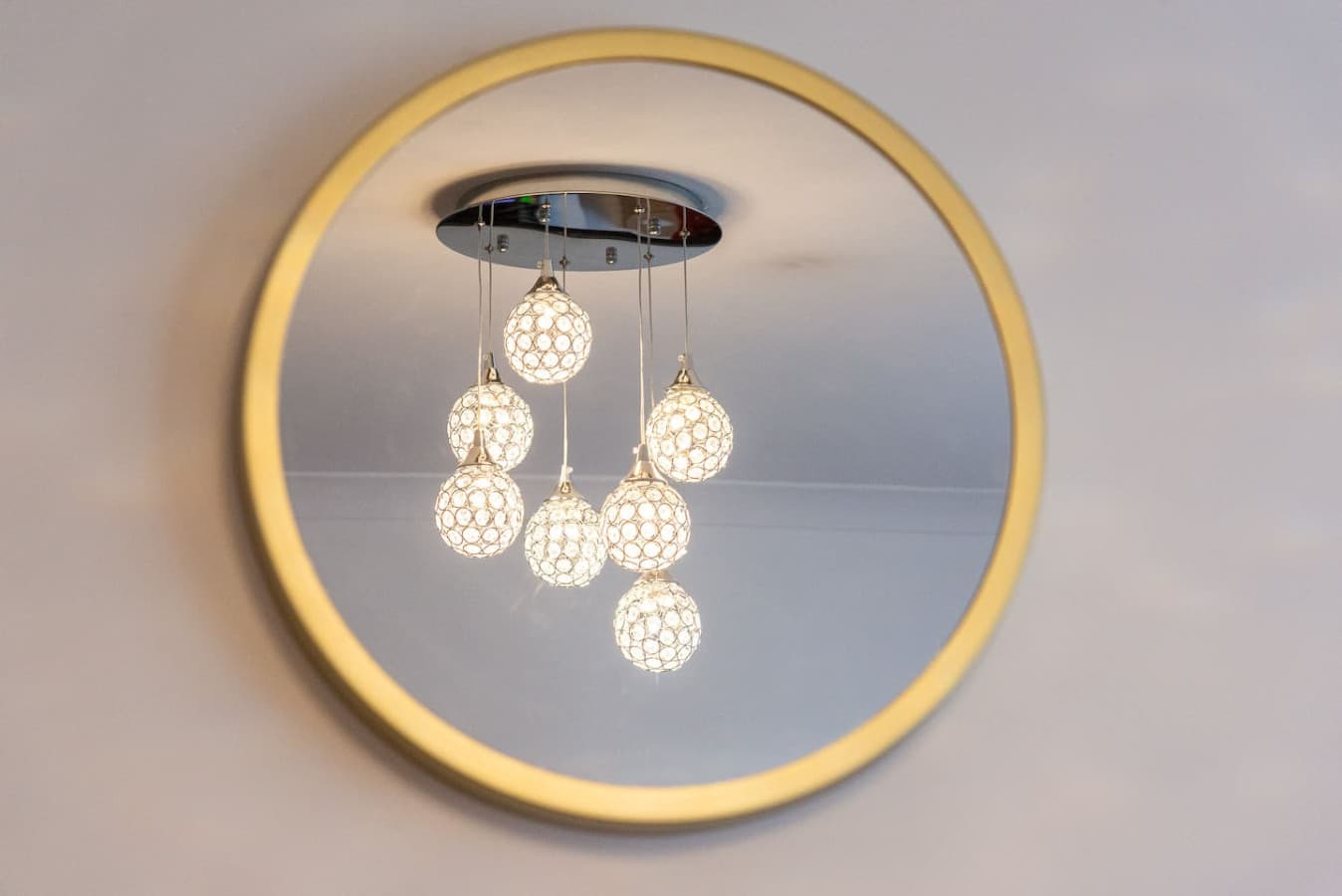 The living room features a decorative mirror and stunning chandelier adding character to the space.