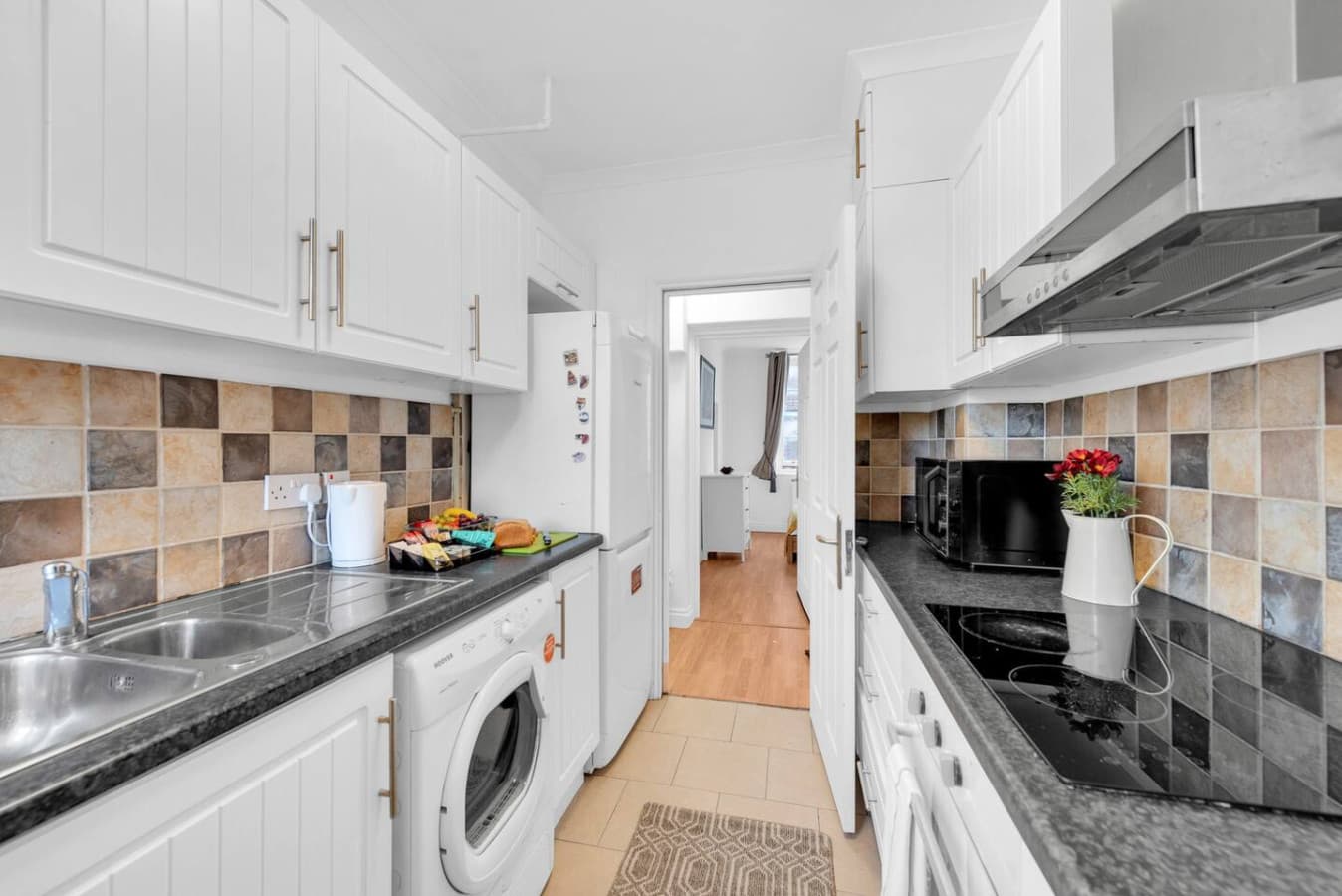 The well-equipped family kitchen is the heart of the home, complete with modern appliances making it a functional and inviting space for cooking and gathering.