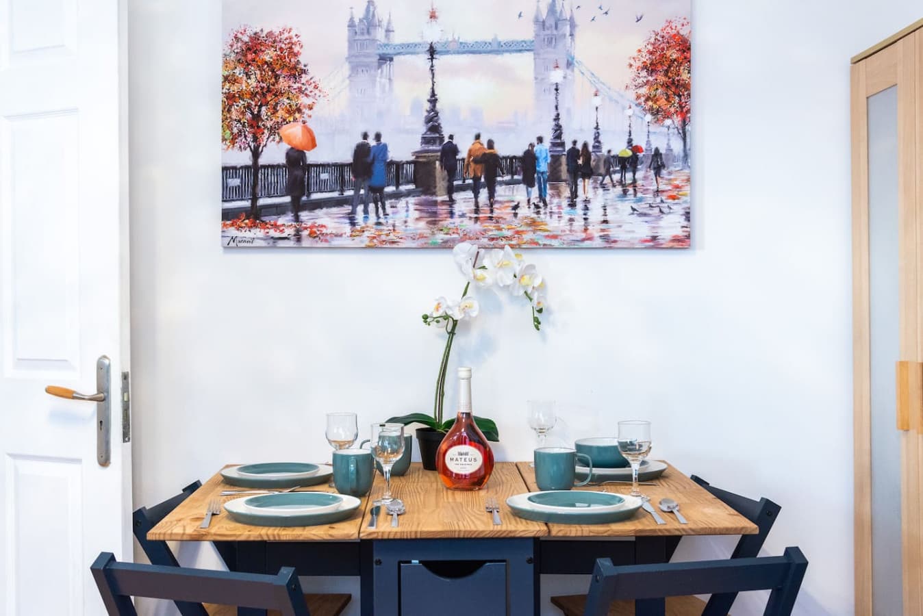 The dining area features a dining table, chairs and an eye-catching painting, creating a bright and stylish space for enjoying meals with family and friends.