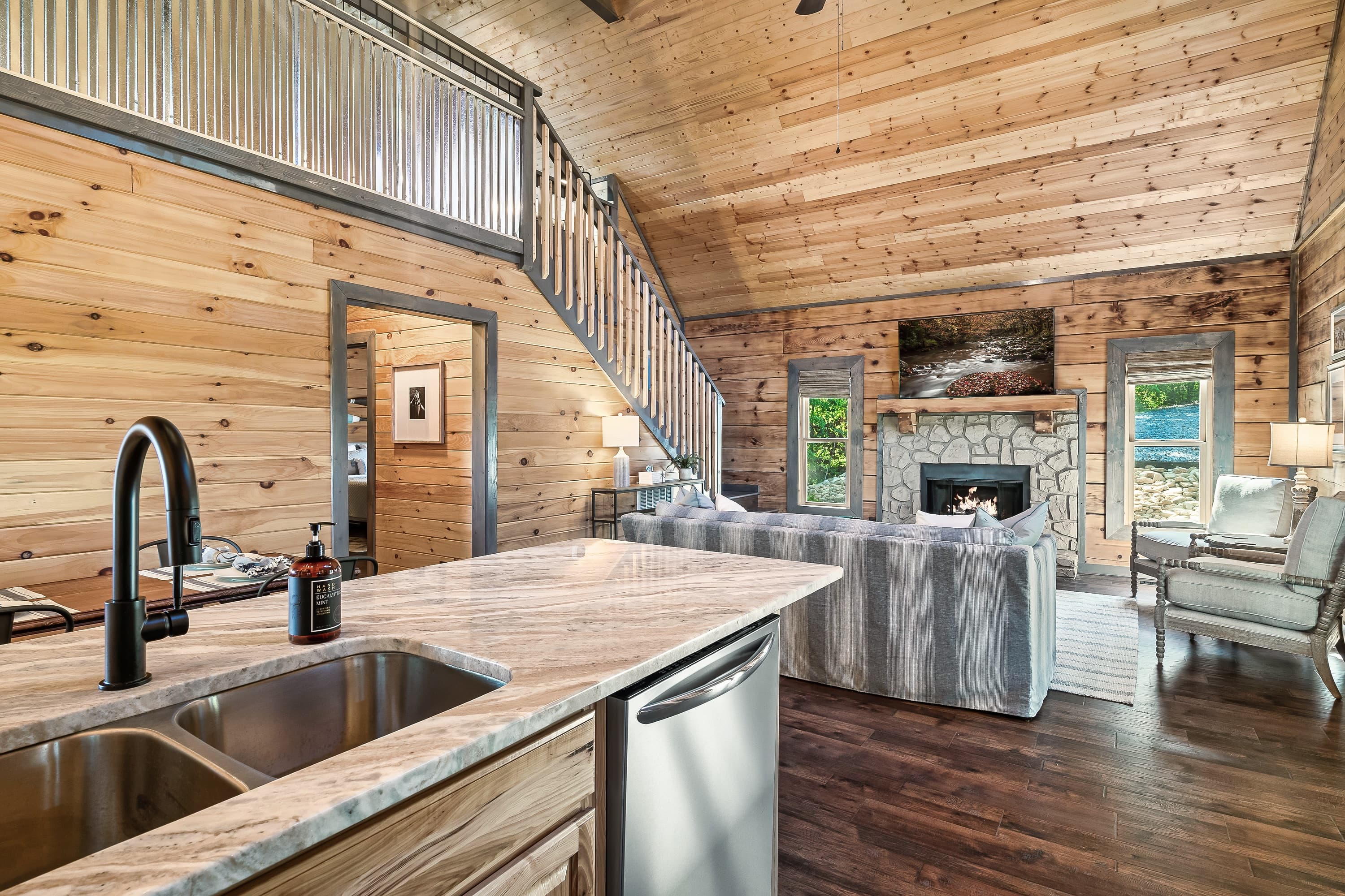 Open kitchen with granite island, stainless appliances, and cabin views
